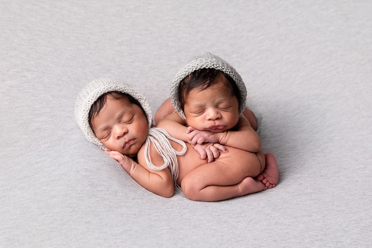 Newborn twin baby girls sleeping together, posed side by side in a studio newborn session by Sarah Kane Photography in Chesterfield Virginia near Richmond VA.