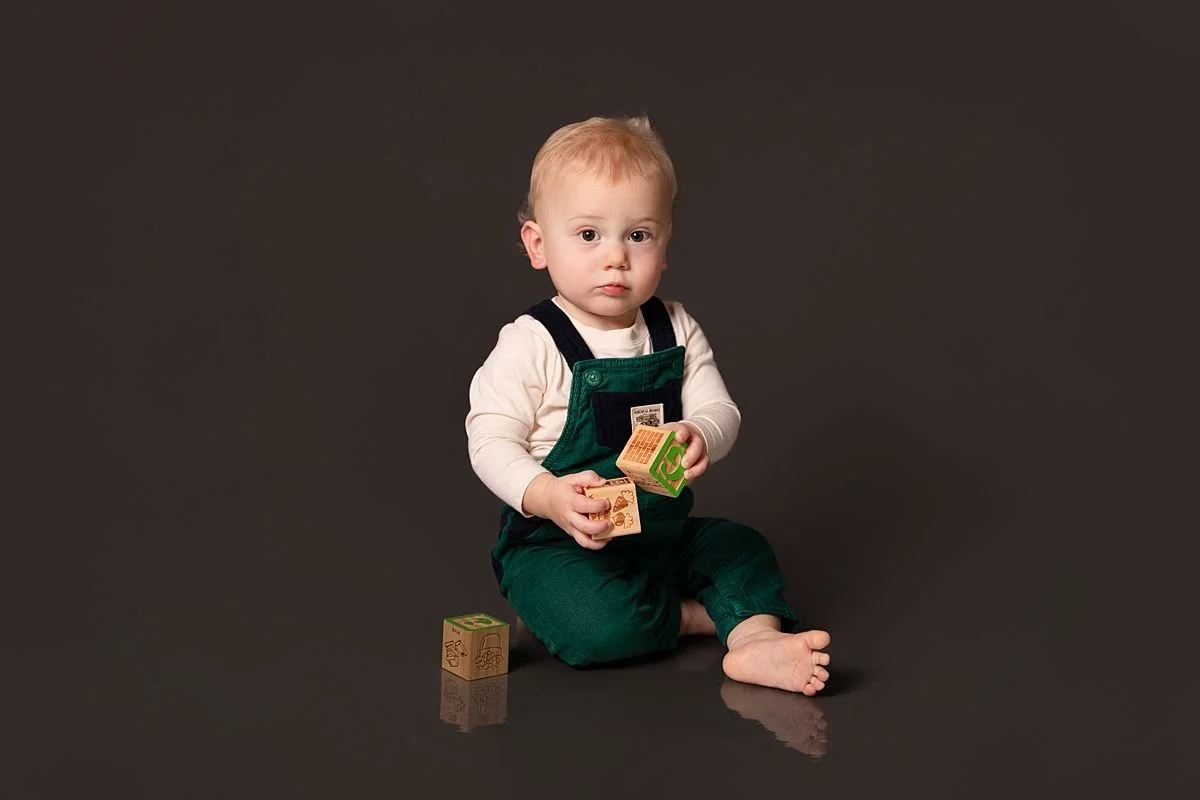 One year old twin sitting with wooden blocks by Sarah Kane Photography