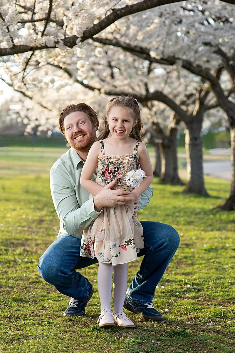 father dressed in a sage shirt posing with his daughter in a floral sundress for family pictures in Richmond Virginia