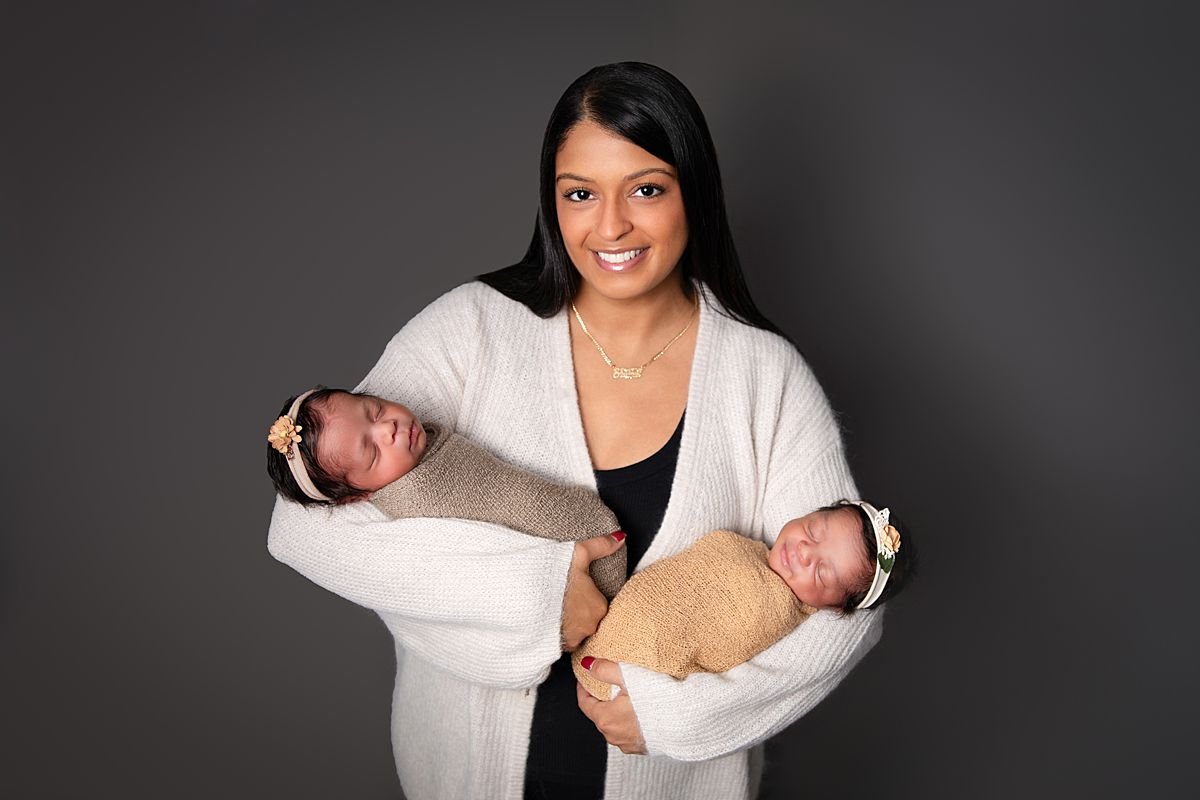 Mother holding twin newborns,  Sarah Kane Photography