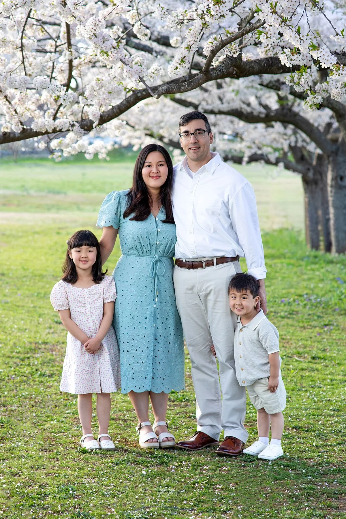 Family standing together under cherry blossom trees during a spring mini session, Sarah Kane Photography, Richmond Virginia