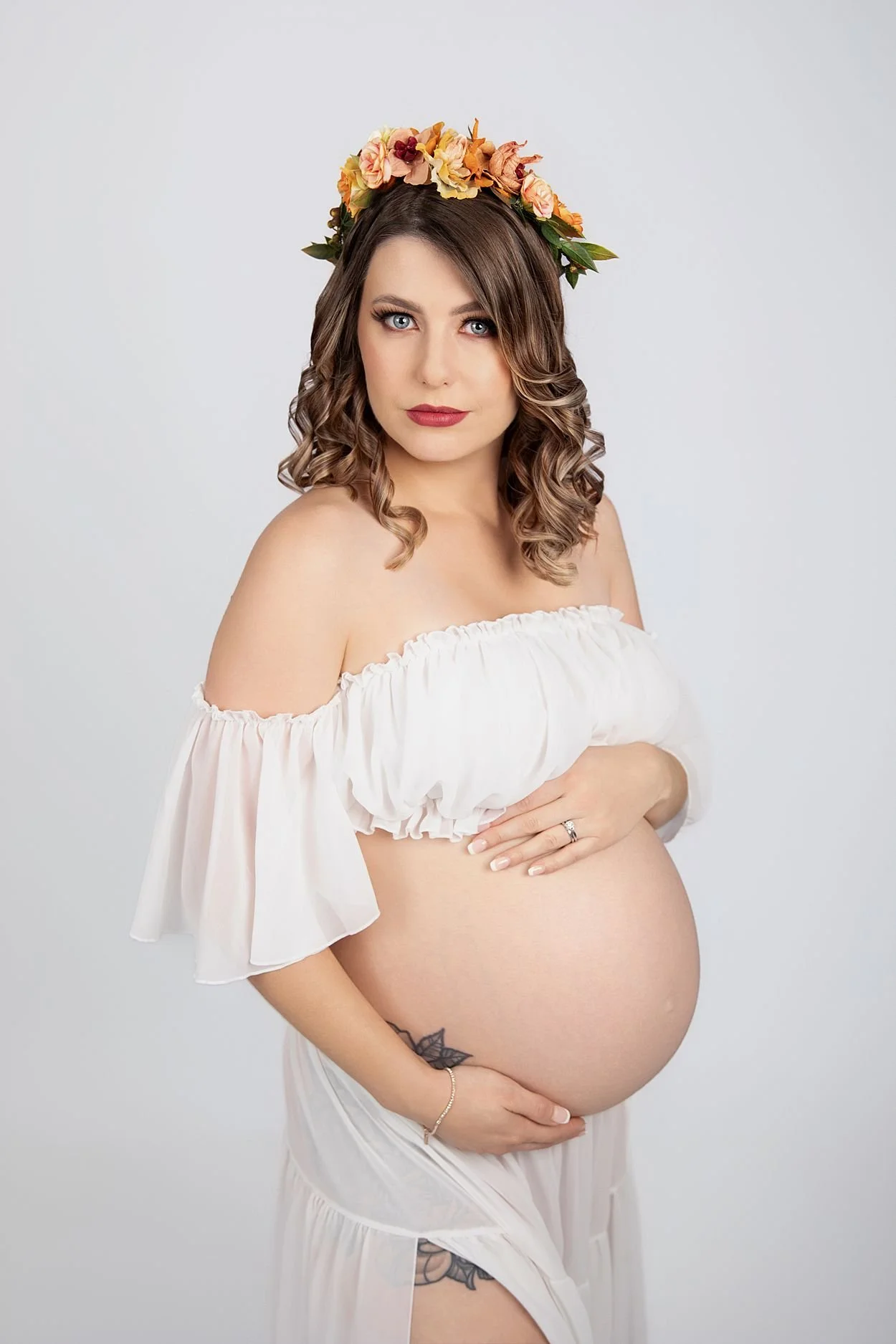 Studio Maternity Photographer in Chesterfield Virginia Just Outside of Williamsburg VA, Pregnant woman holding belly while wearing a sheer white dress