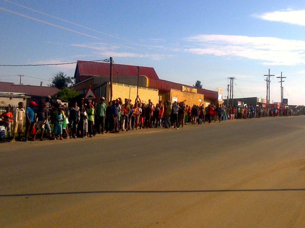 Kids lining the road, waiting for the trucks of bikes to arrive.