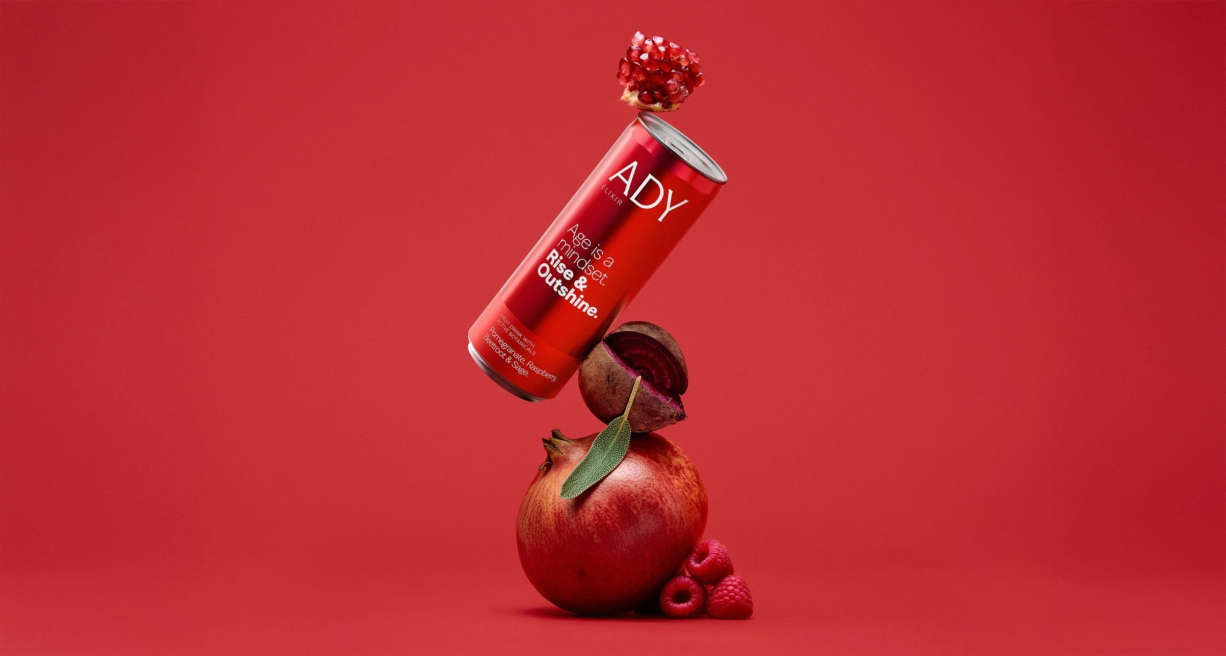 Lata roja de ADY Elixir en equilibrio  sobre fondo rojo. Fotografía publicitaria de producto con 3D e IA - Alfonso + Alicia Studio - Alfonso Herranz