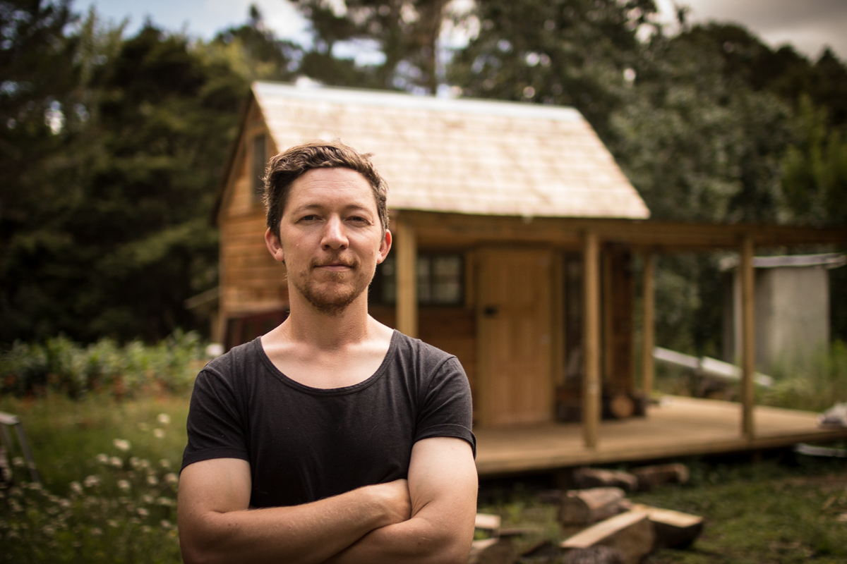 Toby outside his custom built cedar wood cabin home studio, in northland, New Zealand.