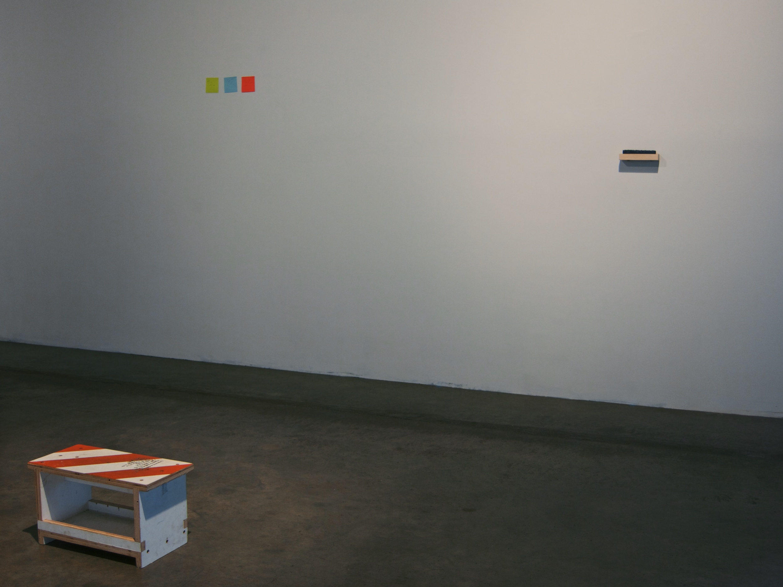  View of Installation. Step stool arranged in front of wall with sticky notes and cut paper wave box. 