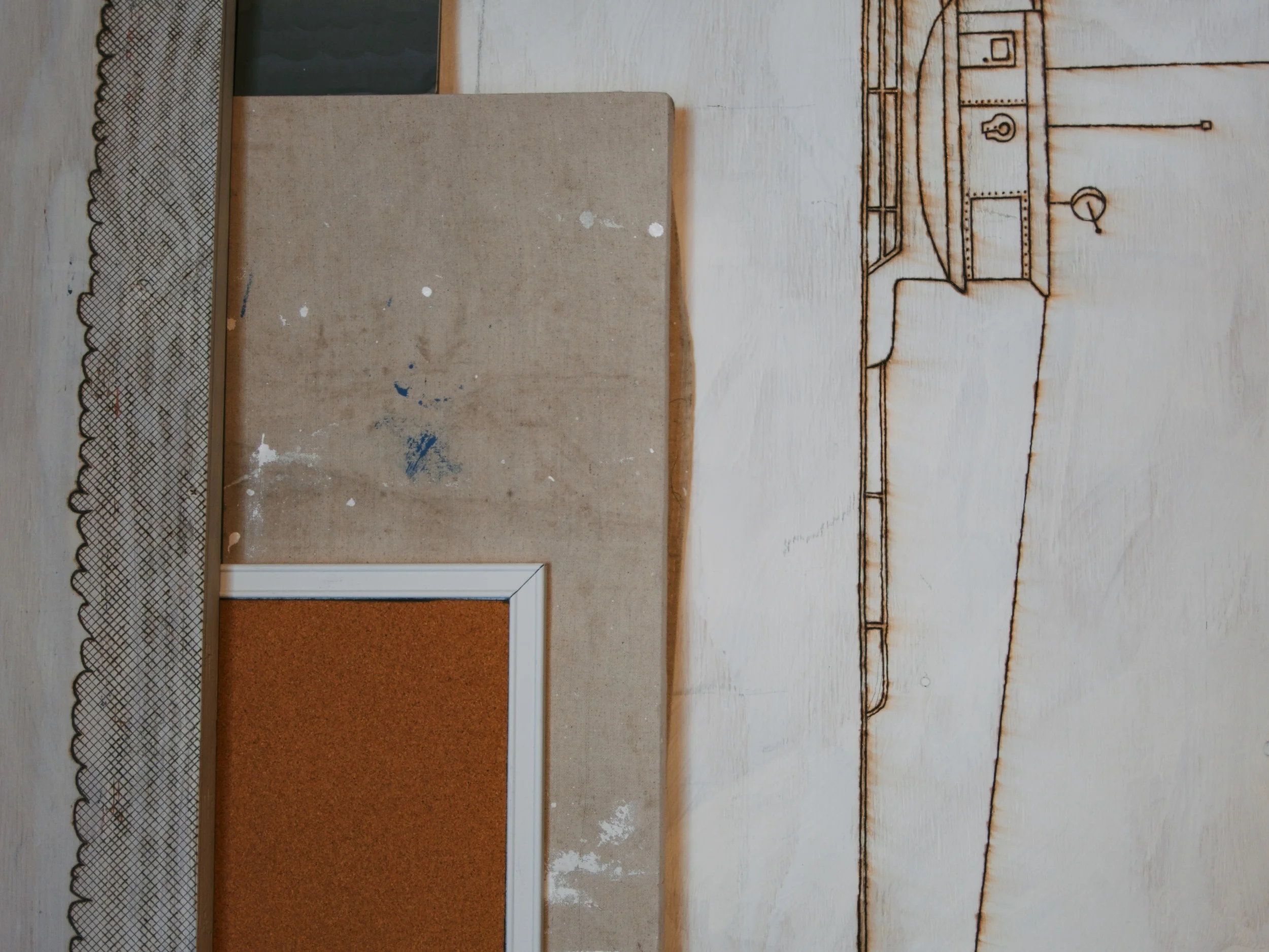 Various plywood scraps leaning against the wall containing abandoned projects that have been wood-burned, painted, and cut into, 8x8 feet, 2014.