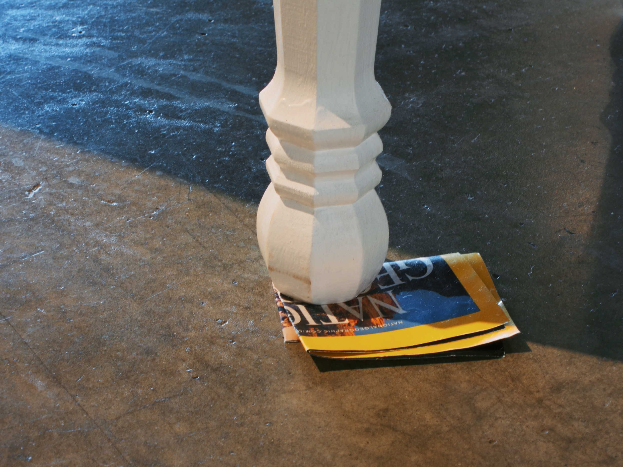  Built coffee table and model ship interiors built from scrap plywood and found table legs with folded National Geographic cover leveling one leg, 24x48x18 inches, 2014. 