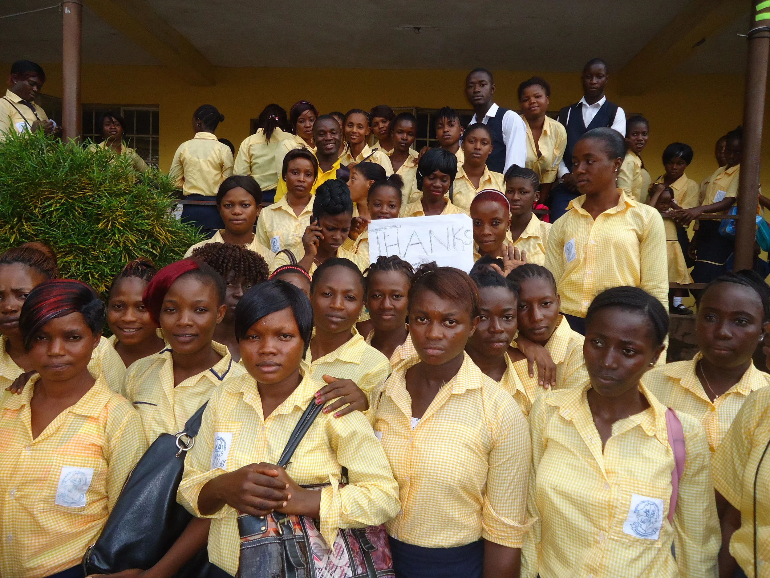 Staff and Students of Women in Action hold a "Thank you" sign for the Esther's Echo 2014 fundraising campaing