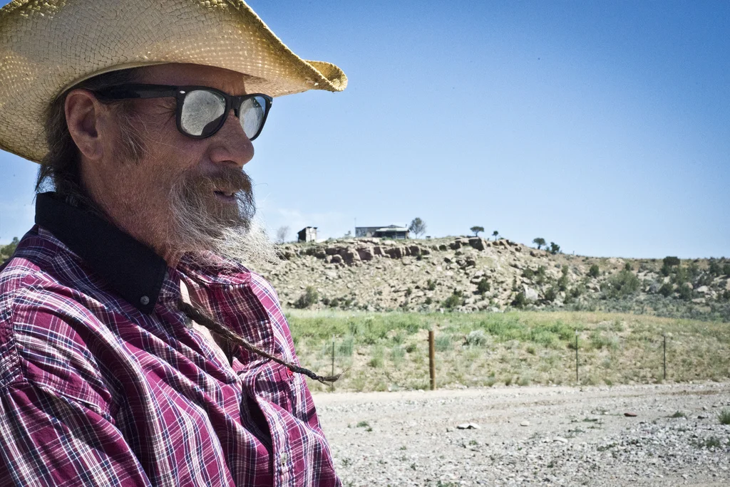 Rick Roles stands beside gas wells on his property in Garfield County, CO