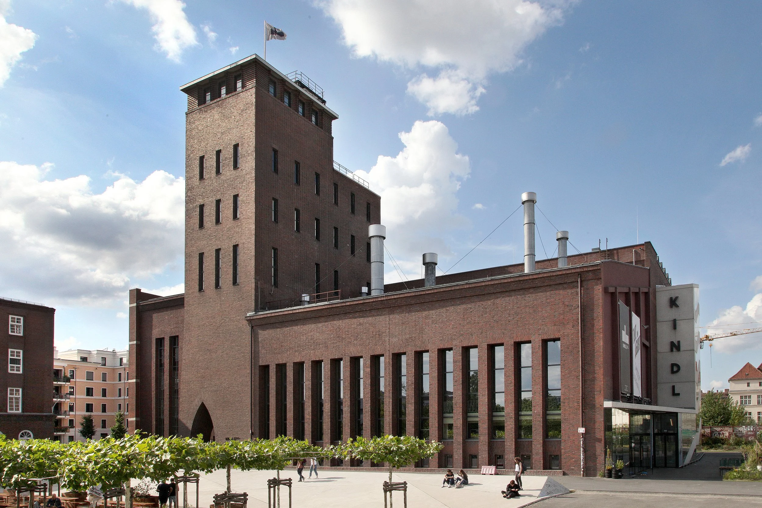  Aktuelle Außenansicht des KINDL – Zentrum für zeitgenössische Kunst.&nbsp;Die denkmalgeschützte ehemalige Brauerei wurde seit dem Erwerb im Jahr 2011behutsam&nbsp;restauriert und durch zeitgenössische Elemente wie das verglaste Treppenhaus mit&nbsp;
