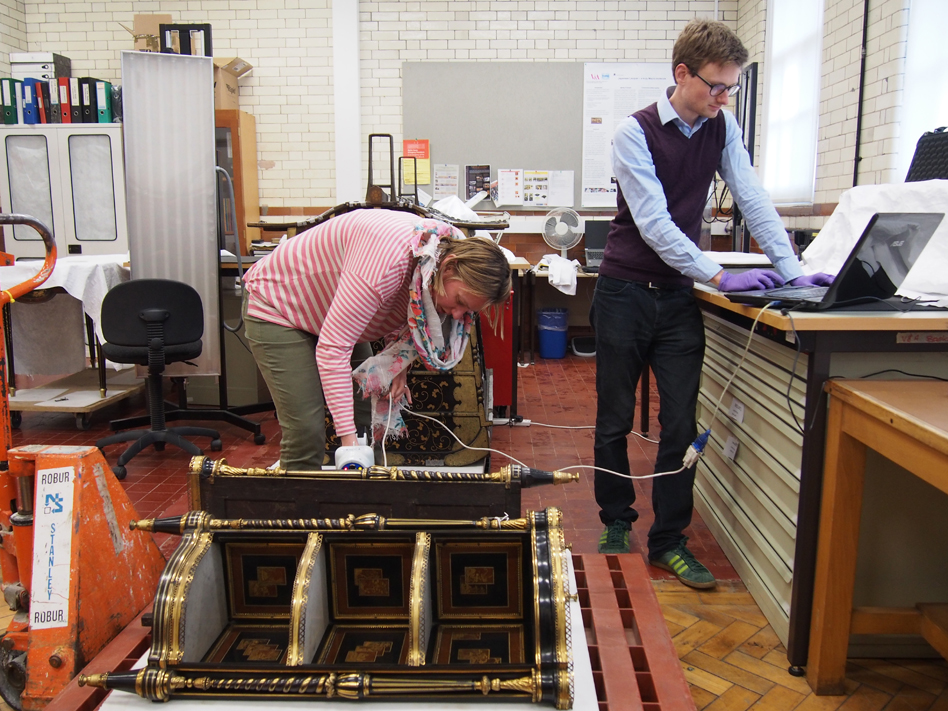Dana and Tristram looking at a pair of 18th century French side tables