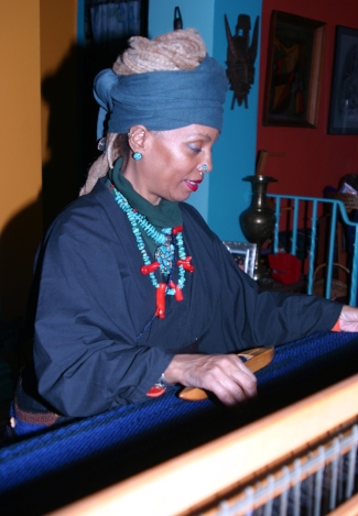 Kaitha Het Heru weaving Khamit Nit Men: Khamit Cloth on her 4 harness, 45" Floor Loom. Photo: Kmur.