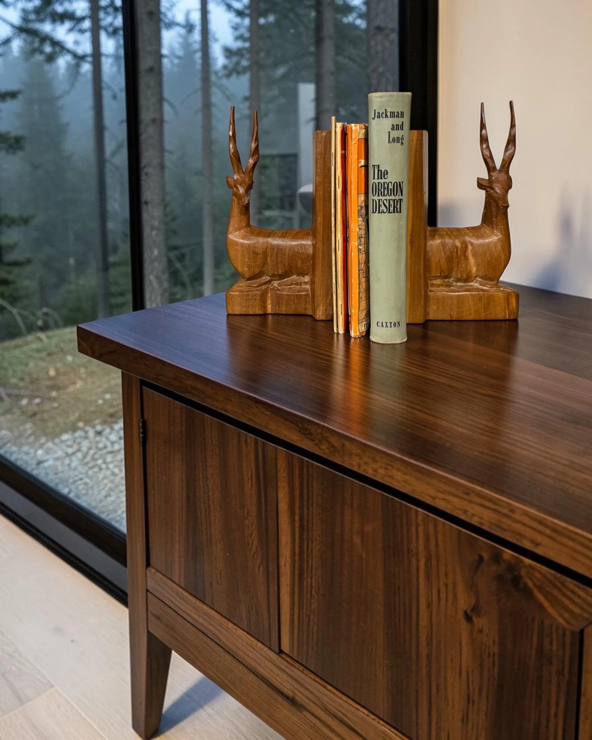 vintage carved wood gazelle bookends staged on a table in a modern cabin