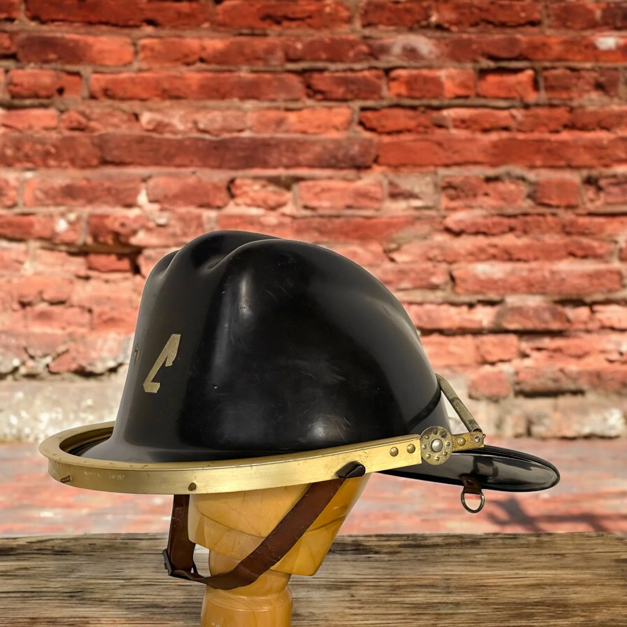 Vintage black firefighter helmet with classic design, an antique fireman collectible perfect for display, gift for fireman memorabilia, or fire department decor.