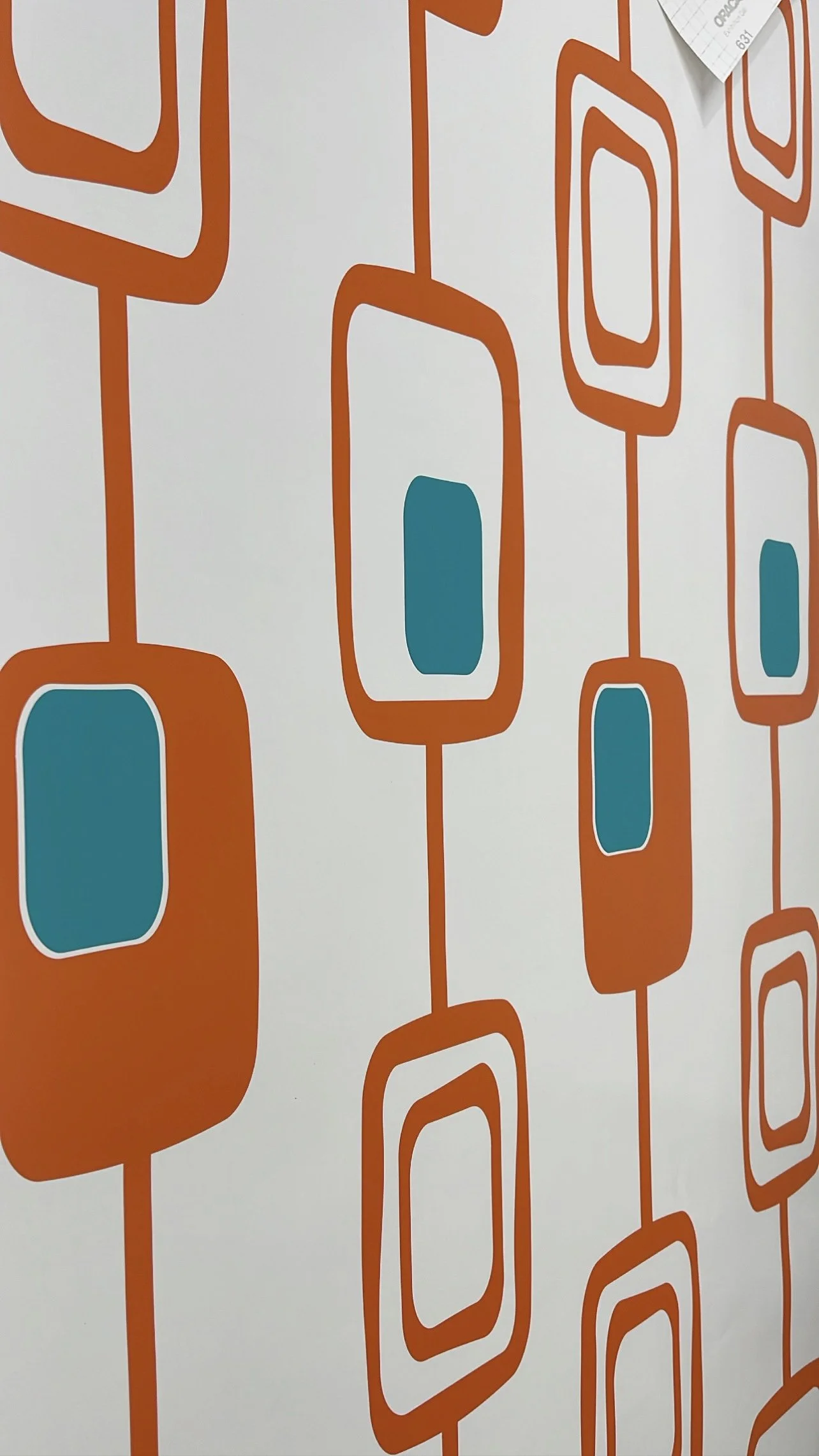 A 2 color vinyl wall decal shown in a geometric rounded rectangle pattern in orange and turquoise, installed on a white wall.