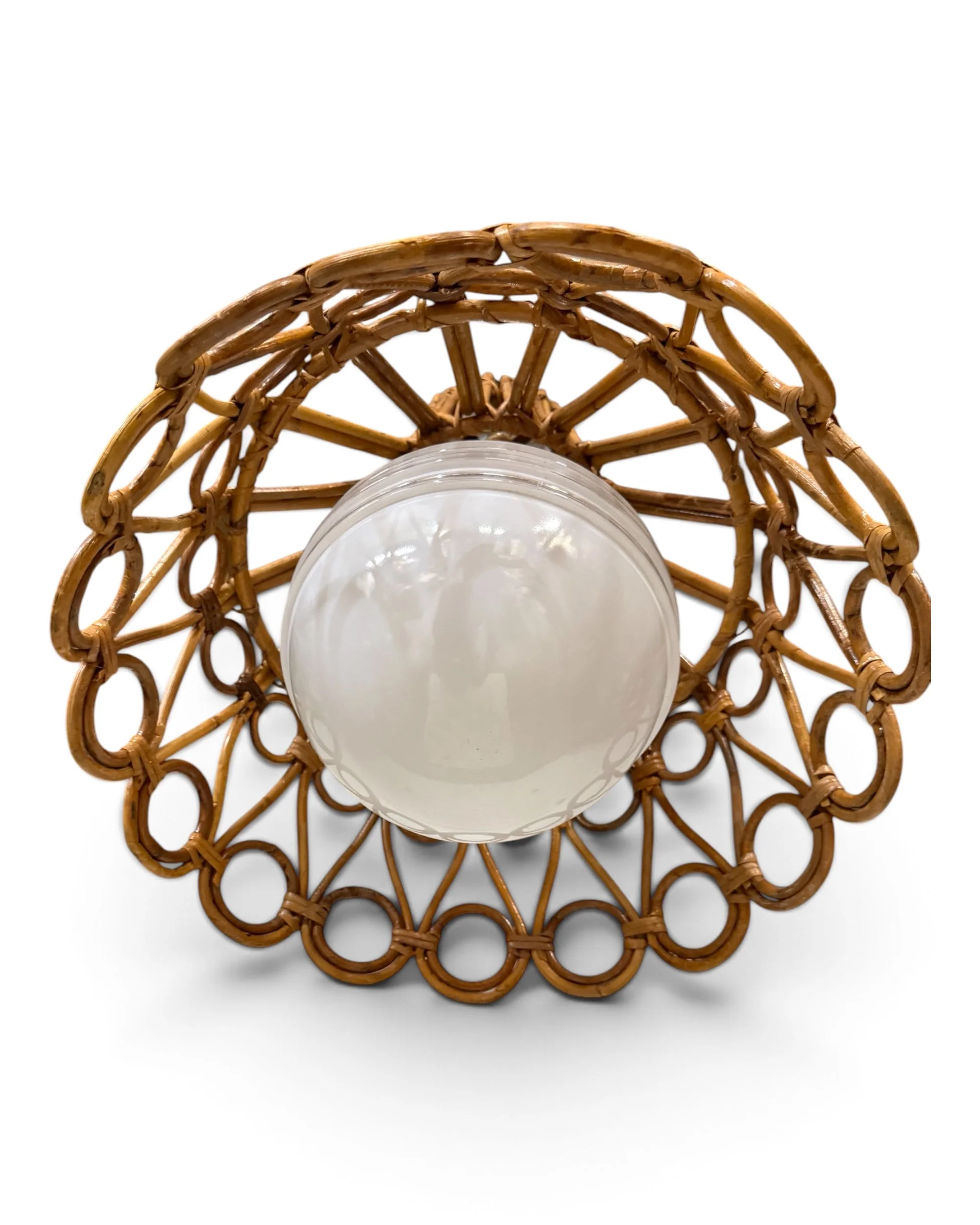 Vintage rattan light featuring a clear and white glass globe surrounded by woven wicker