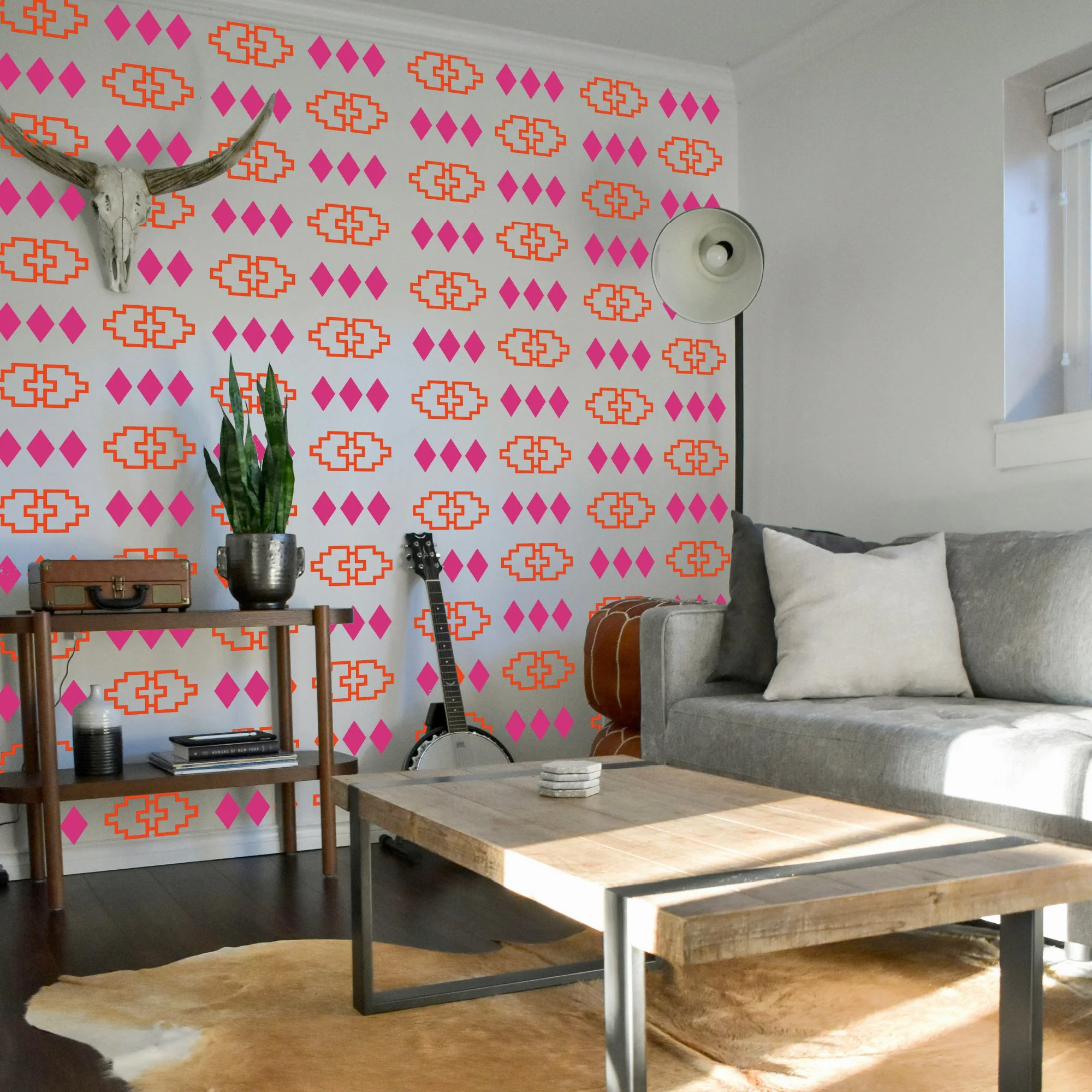 Living room with removable vinyl wall decals in Western Navajo geometric design, featuring orange and pink patterns. Boho Southwestern themed decor.