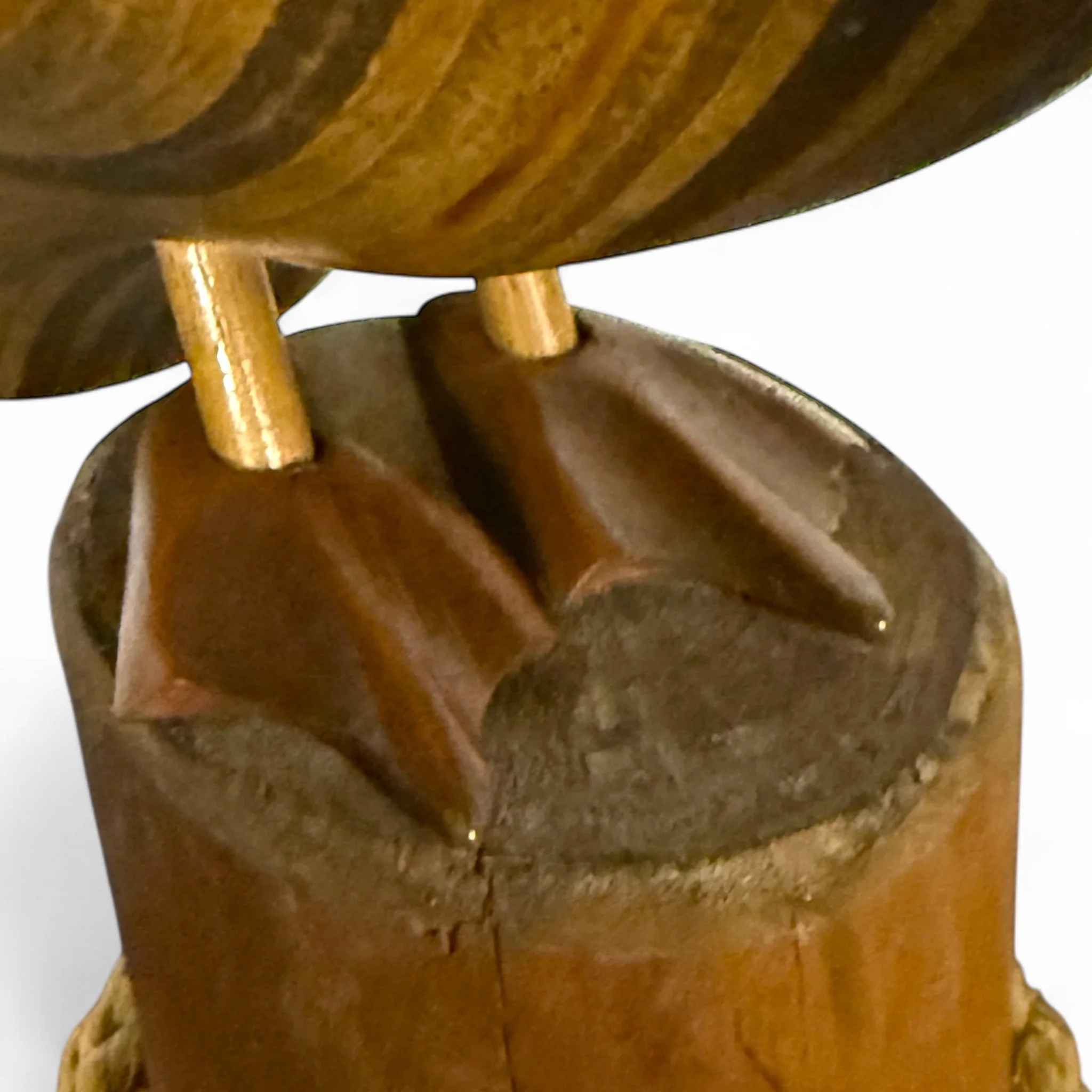 close up view of carved wooden webbed feet on a vintage folk art statue