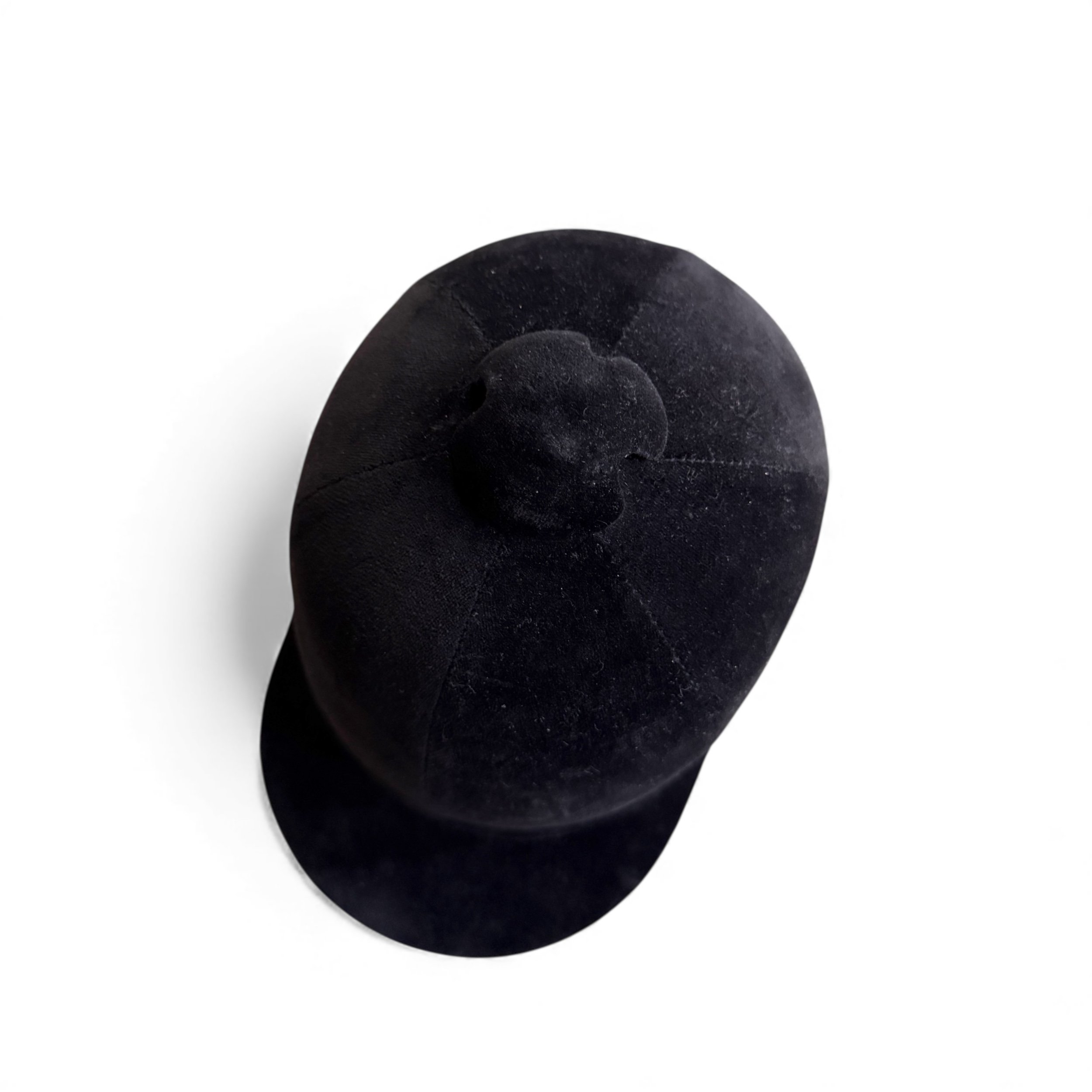 Top view of vintage equestrian hunt cap showing helmet shape and velvet finish.