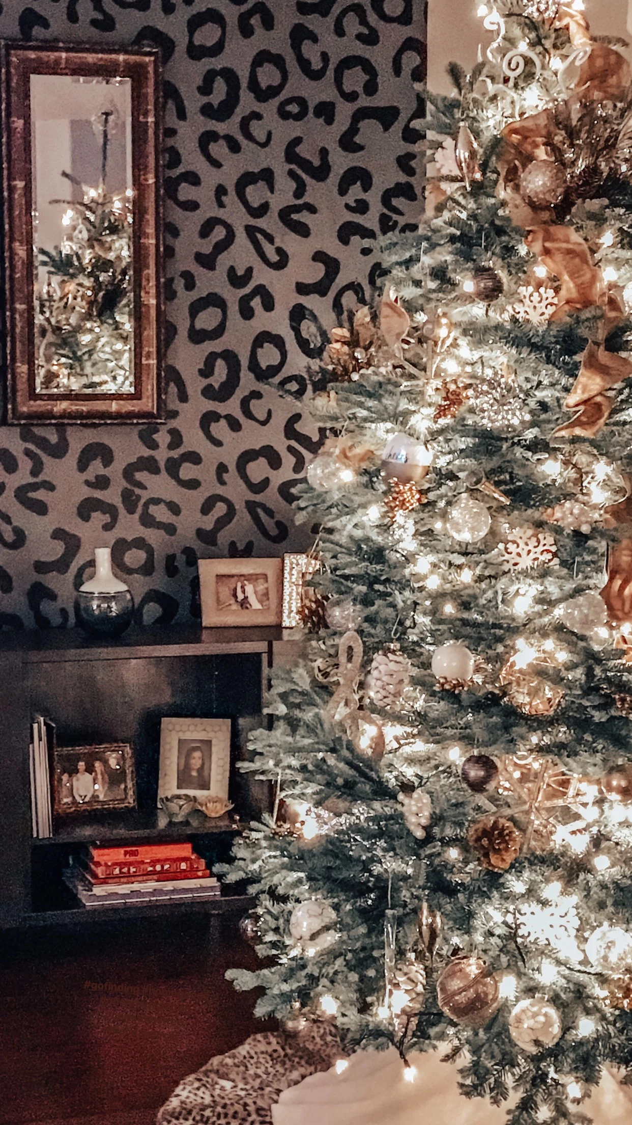 Leopard print wall decals shown in black on a dark grey wall of a modern living room with a decorated Christmas tree.