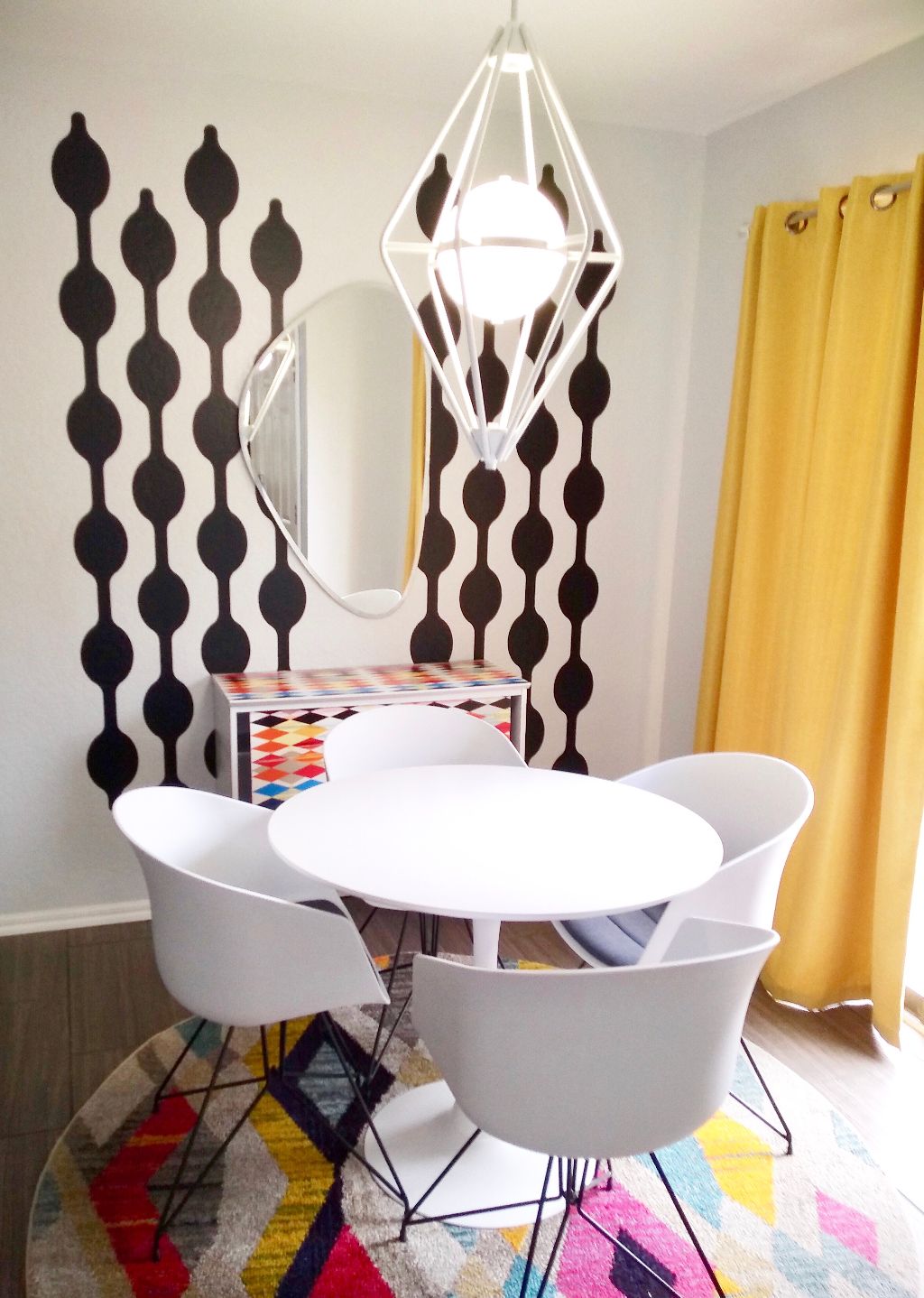 Geometric chain wall decal shown in black on a white wall in a mid century modern style dining room.