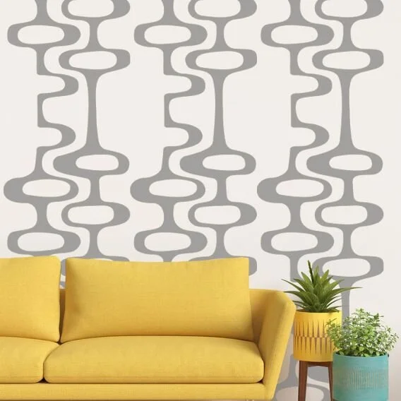 Mid Century geometric pattern wall decal by Wall Star Graphics shown in grey on a white wall above a modern yellow couch.