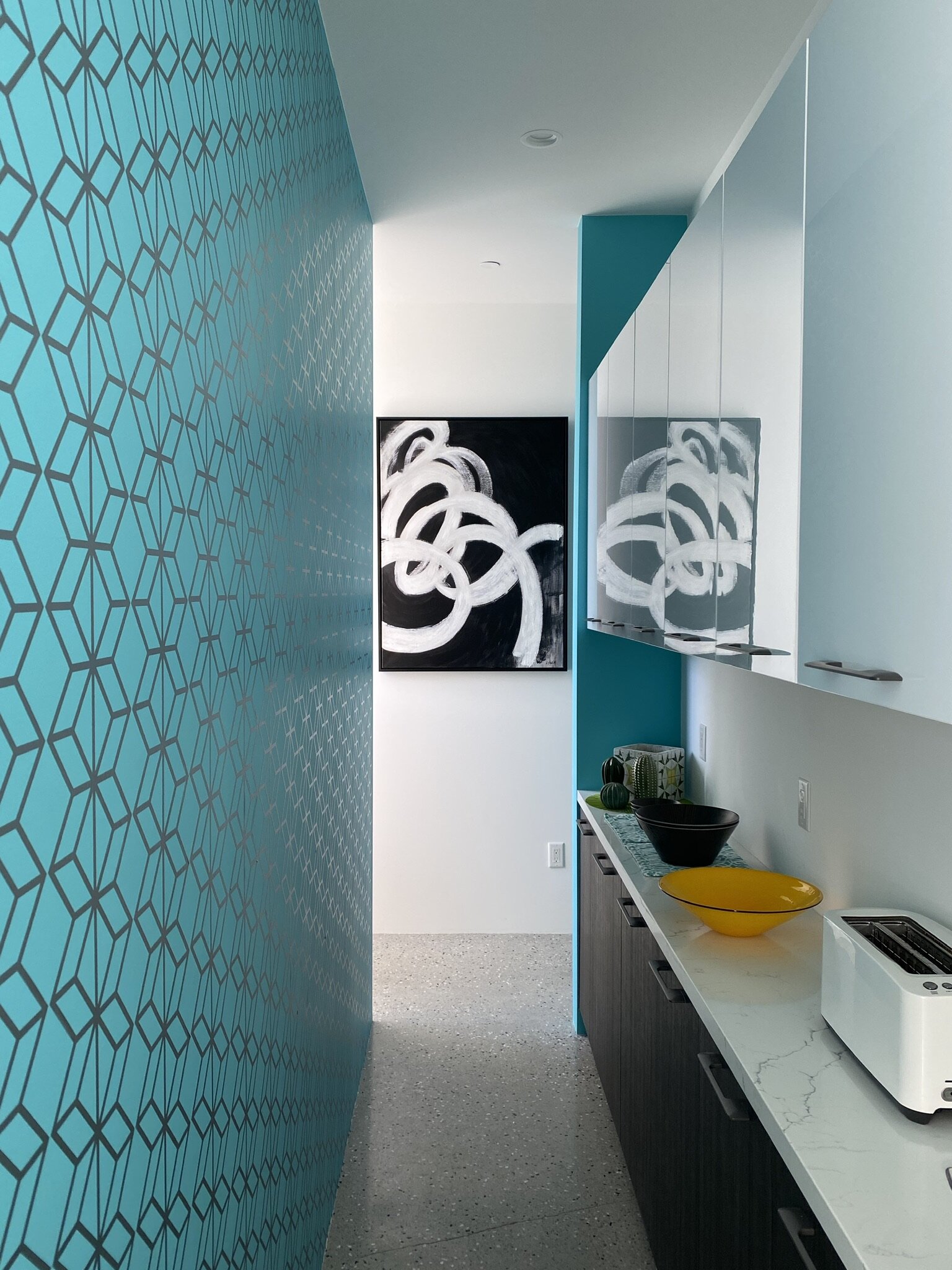 Geometric pattern wall decal shown in metallic silver installed on a turquoise wall in a butler's pantry.