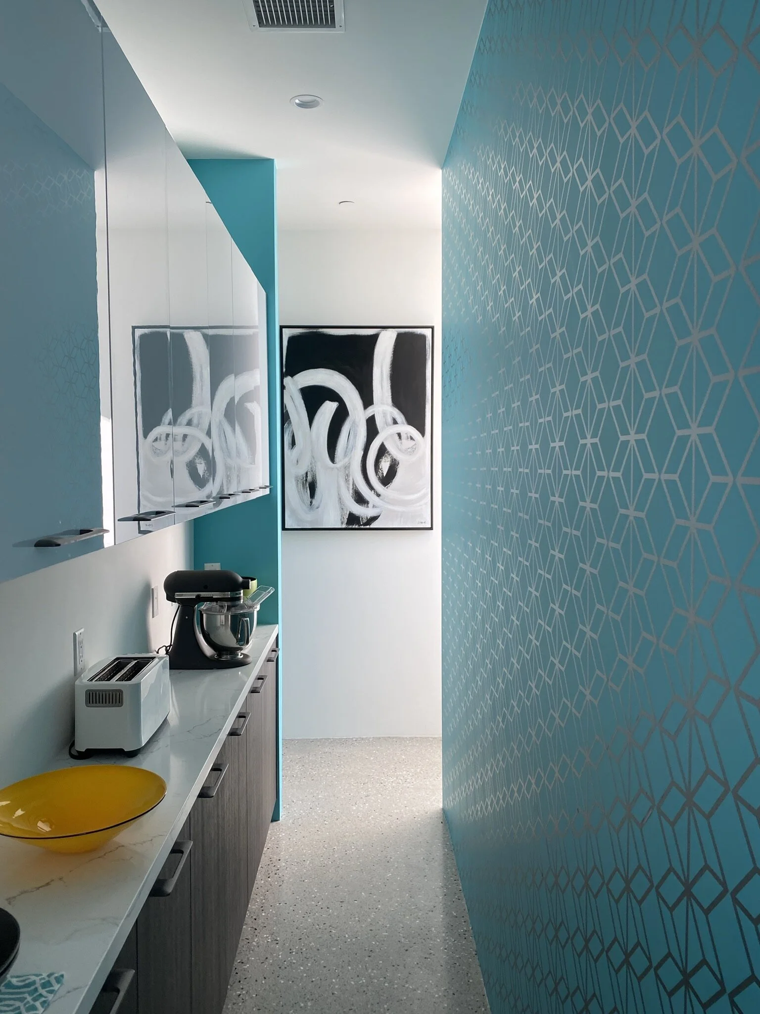 Geometric pattern wall decal shown in metallic silver installed on a turquoise wall in a butler's pantry.
