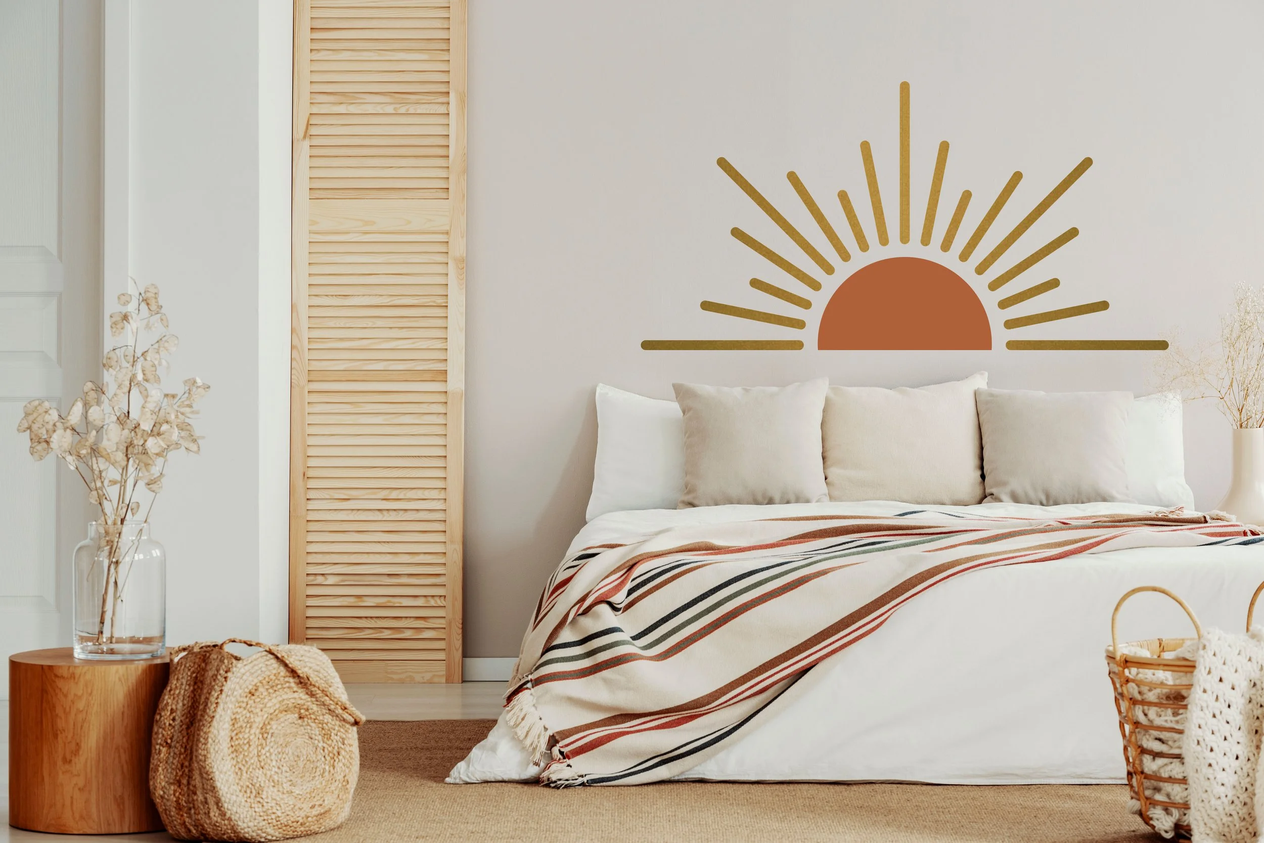 Boho chic style two color sunrise, sunset wall decal shown on the wall above a bed.