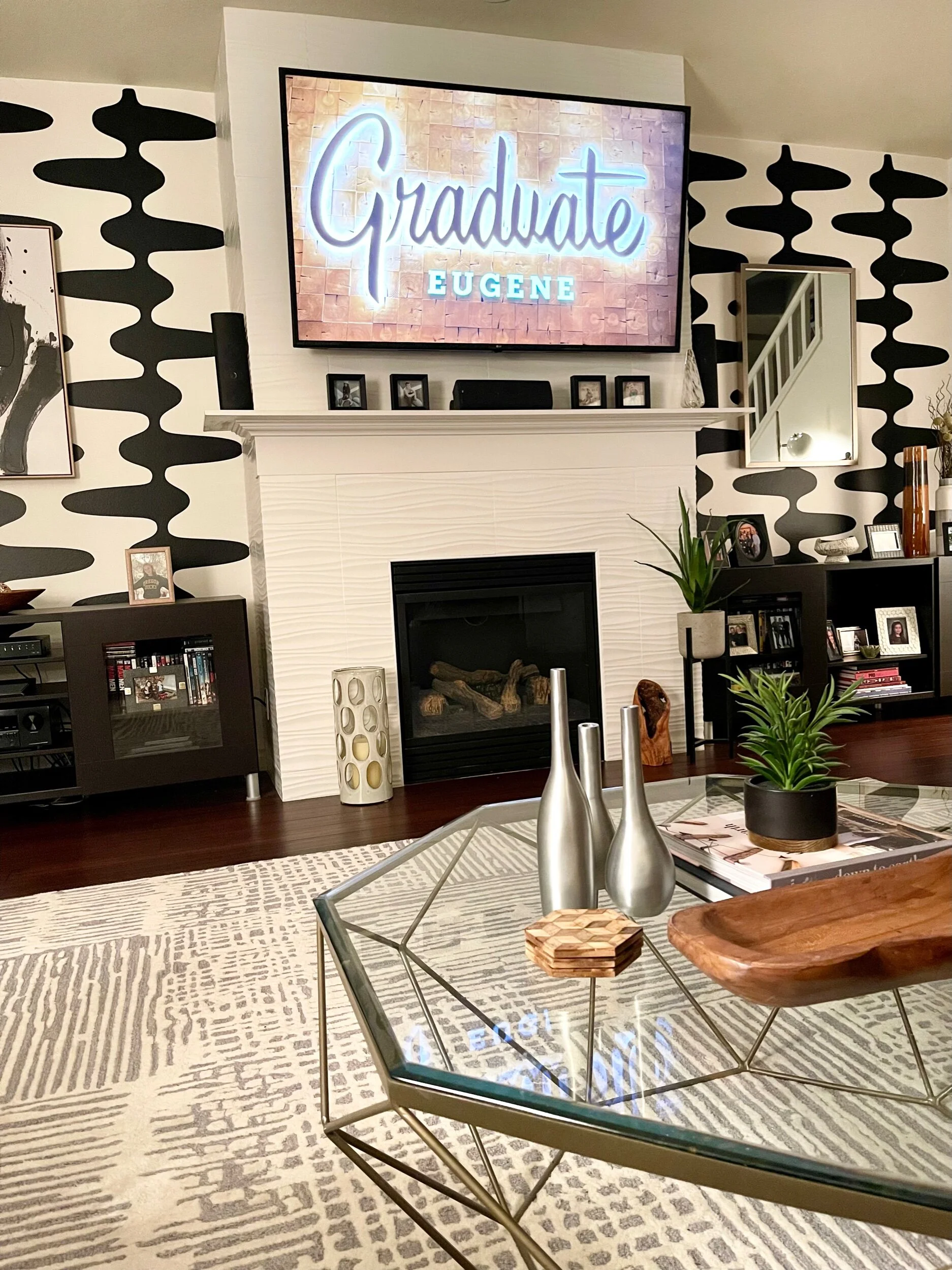 Retro and mid century inspired geometric wall decal pattern shown in black on a white wall in a modern living room.