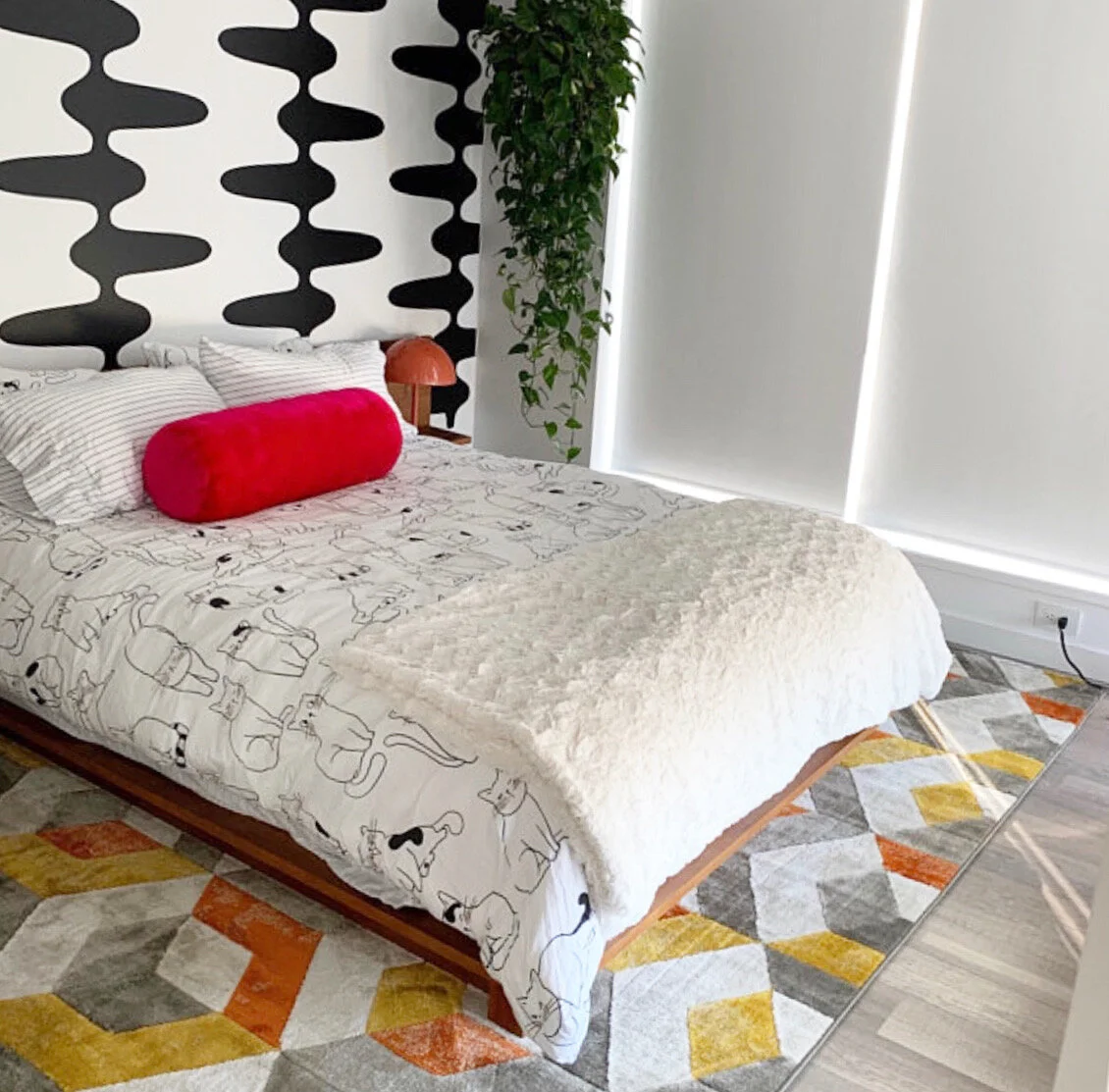 Retro and mid century inspired geometric wall decal pattern shown in black on a white wall in a primary bedroom.
