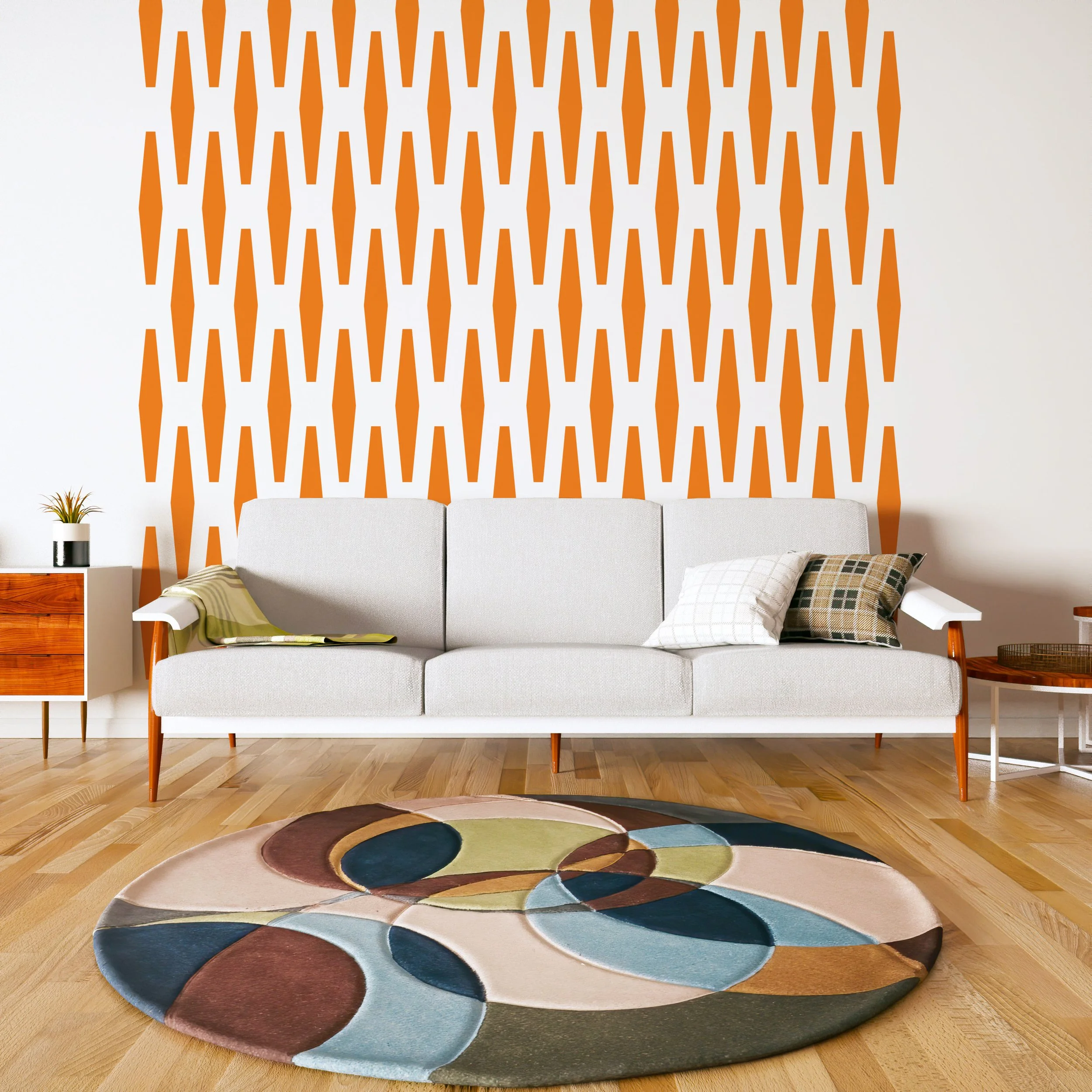 Geometric wall decal pattern in the shape of an elongated hexagon, shown in orange on a white wall of a modern living room.