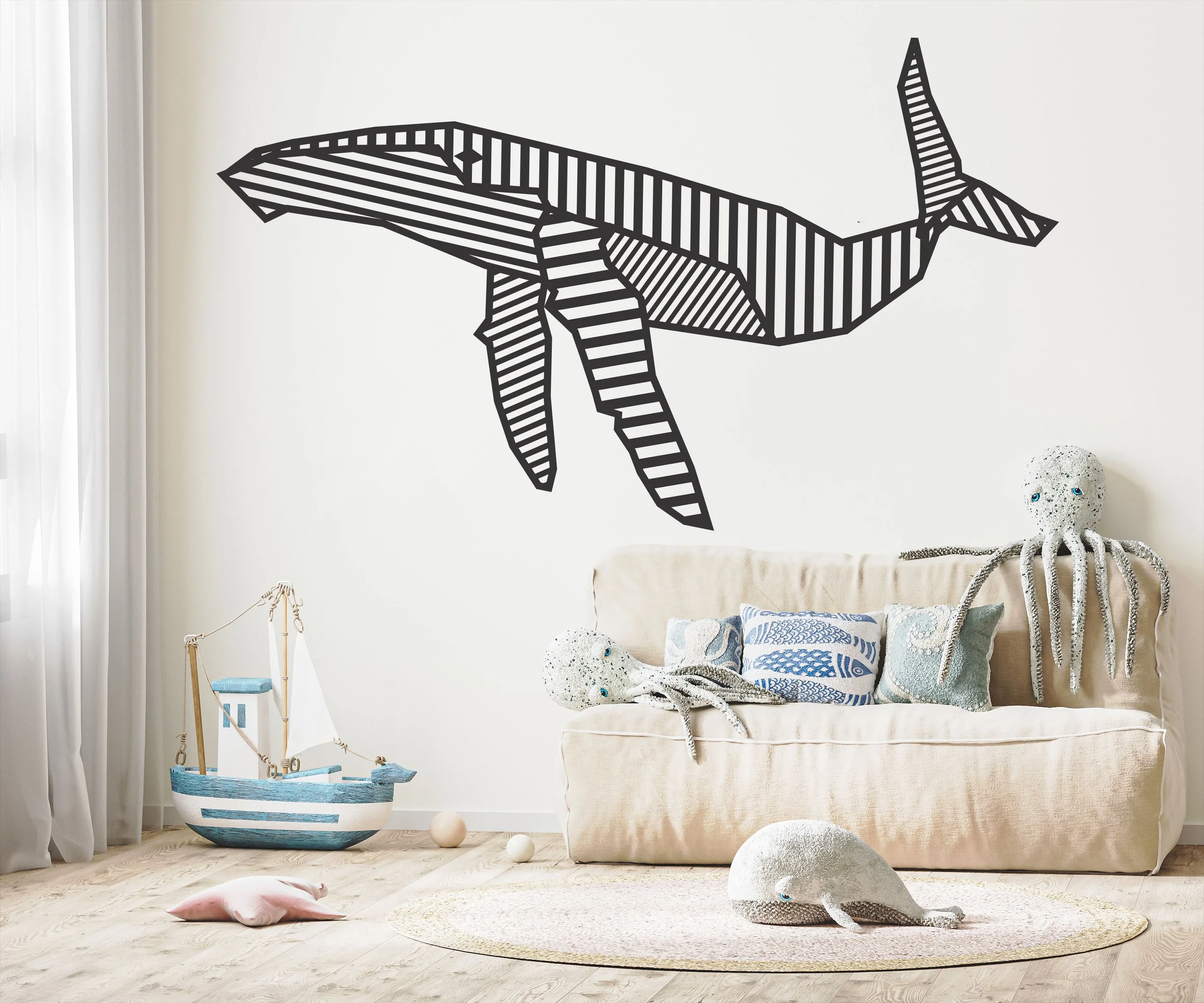 Large geometric, stylized humpback whale wall decal shown on a white wall in a modern nursery.