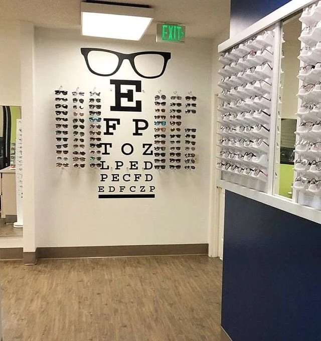 Eye chart wall decal including retro glasses shown in black on a white wall of a modern optician's office.