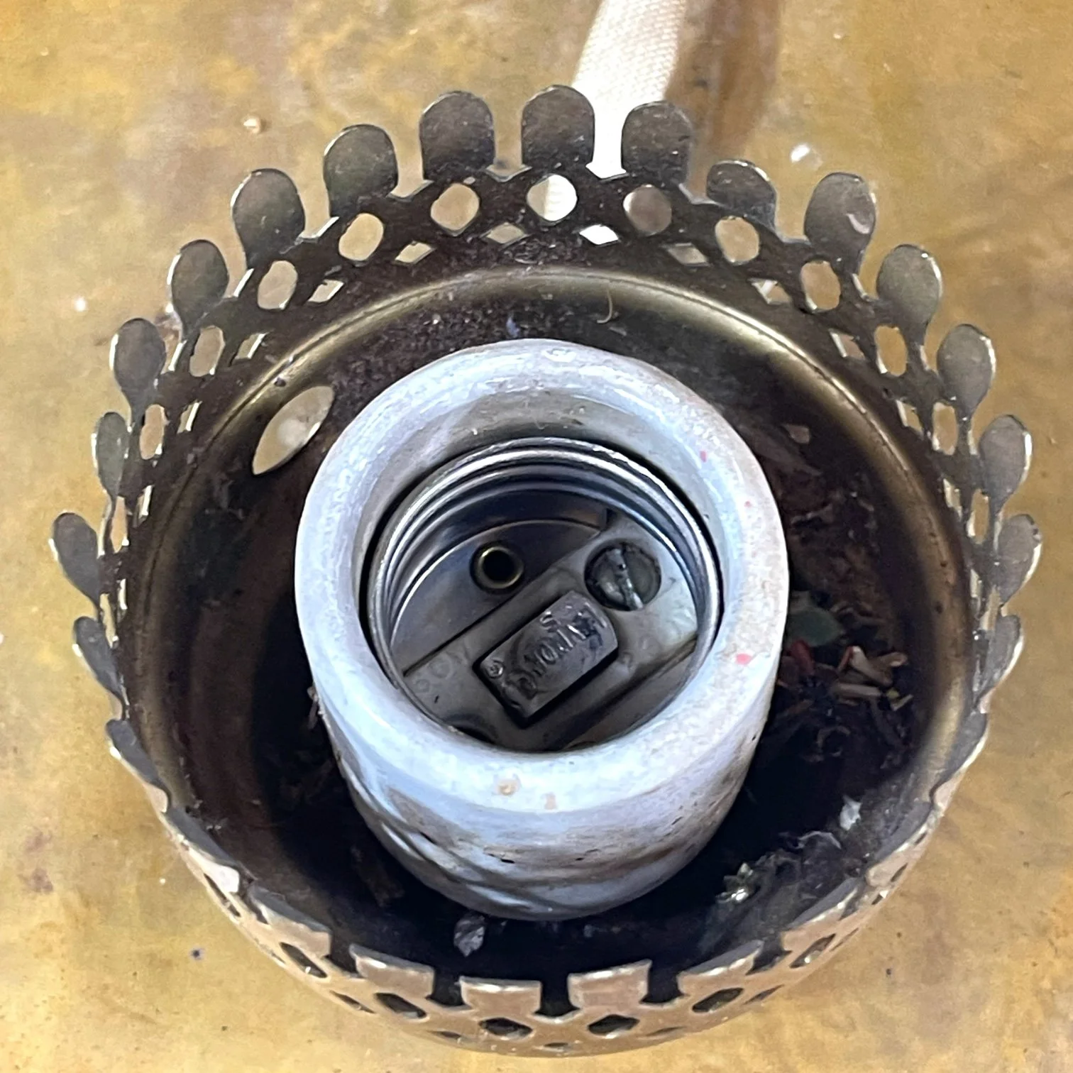 Up close view of a vintage ceramic Leviton socket on a vintage pair of hard wired brass nautical lantern lights suitable for indoor/outdoor use, made by Hollywood Lighting Fixture Co.