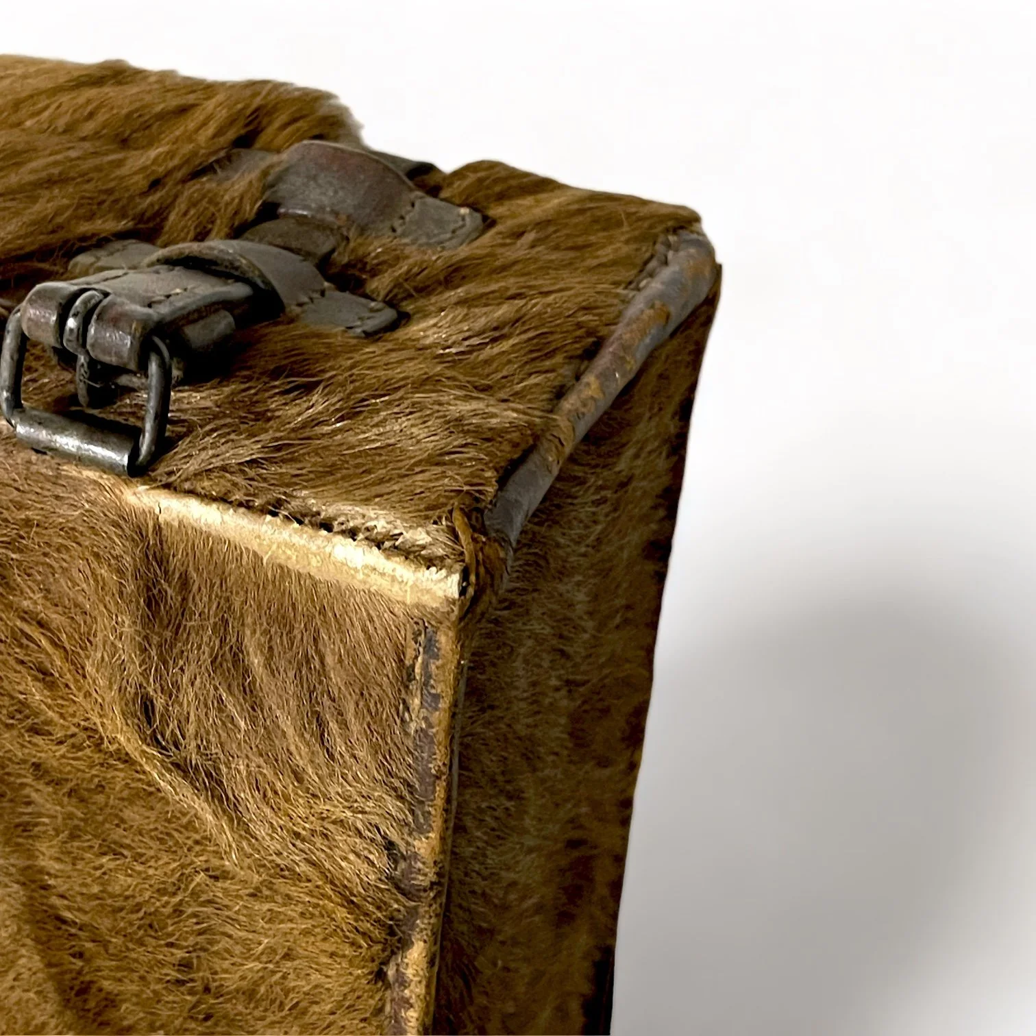Close up of a Vintage 1940s brown Swiss Military Tornister Pony Hair Rucksack in the shape of a square with leather straps and buckl