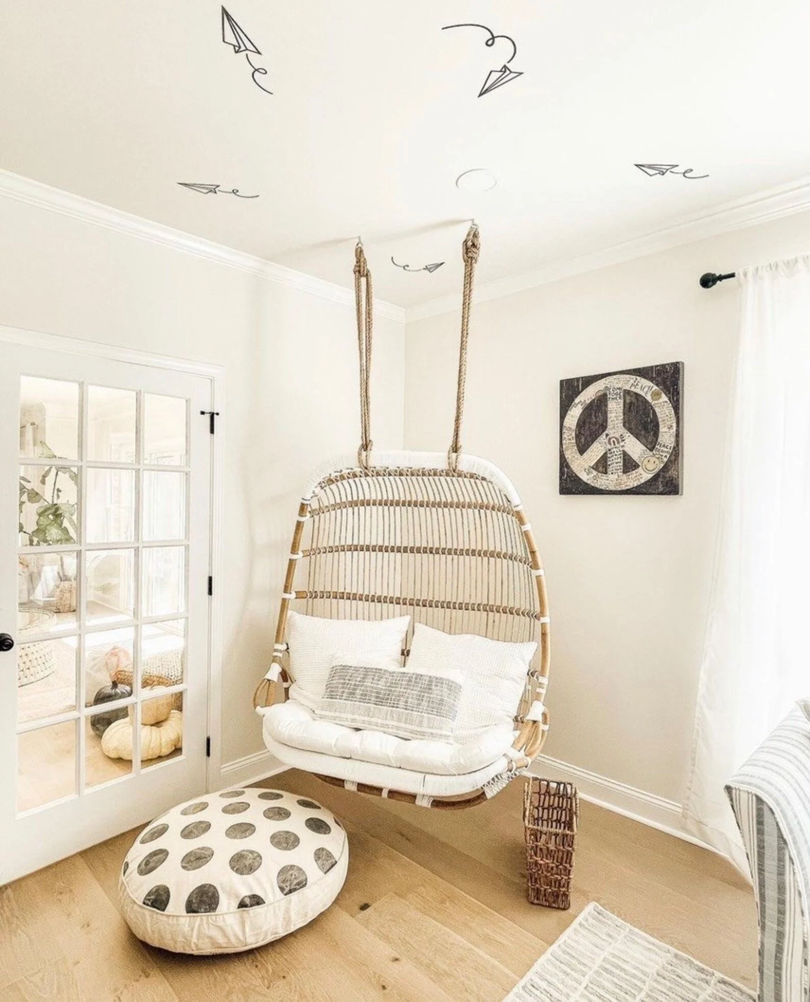 Flying paper airplane wall decals shown in black on the ceiling of a scandi boho style kids bedroom.
