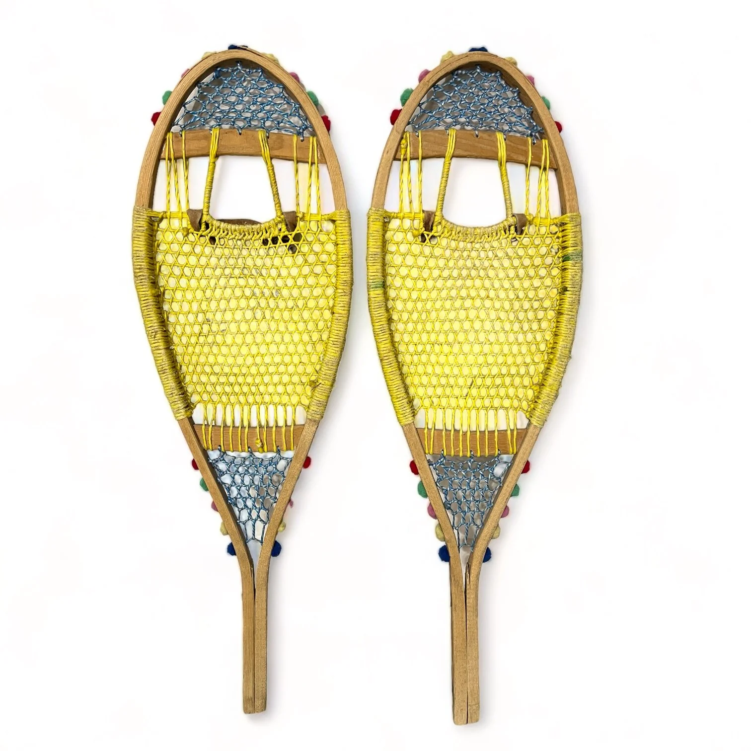 Back view of yellow and blue wooden vintage snowshoes with leather straps.