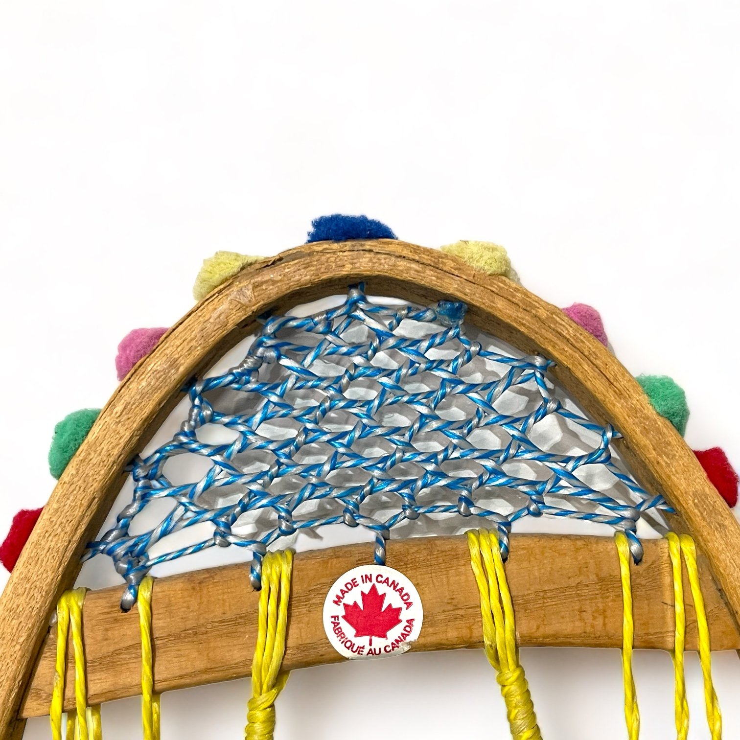 Yellow and blue wooden vintage snowshoes with leather straps.