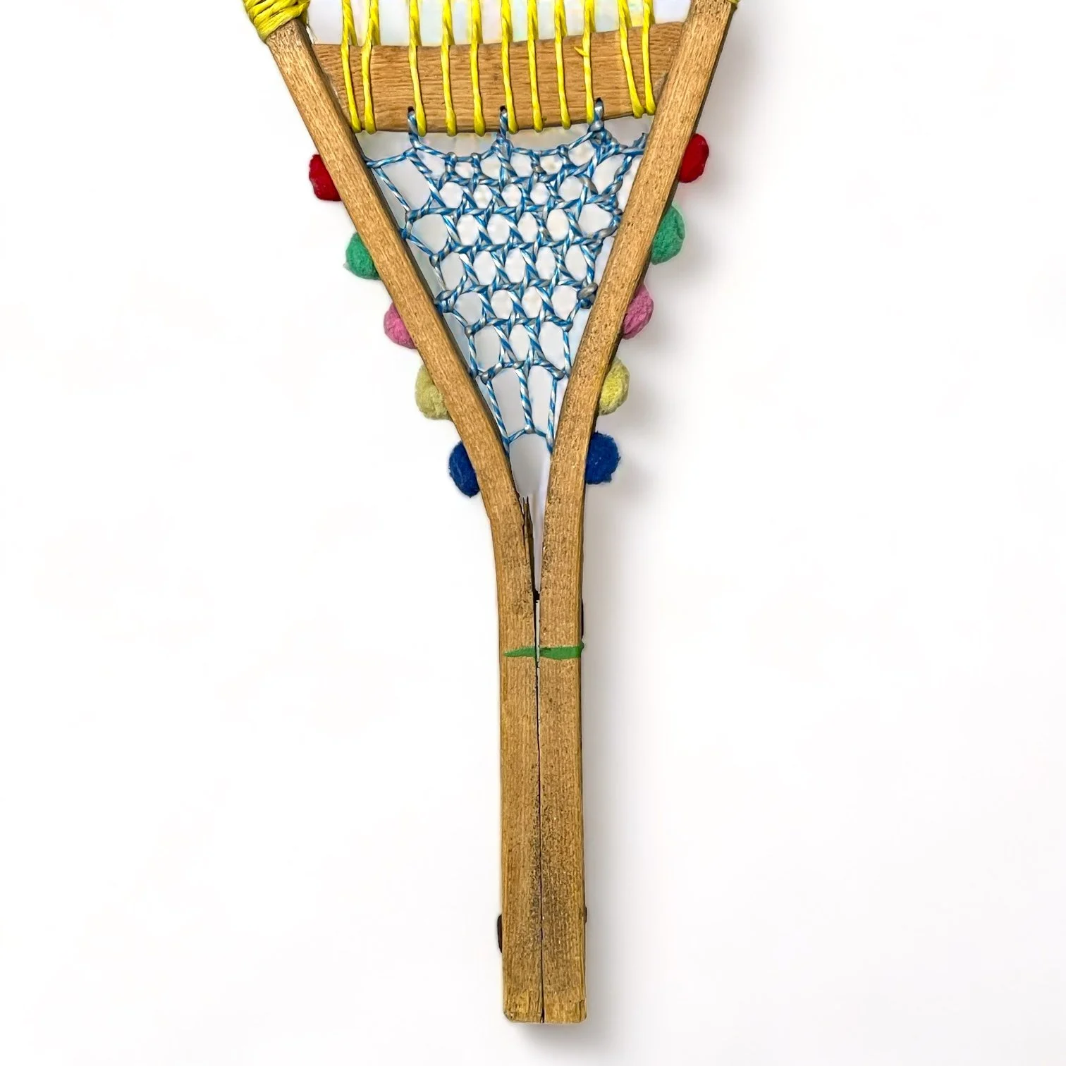 Yellow and blue wooden vintage snowshoes with leather straps.