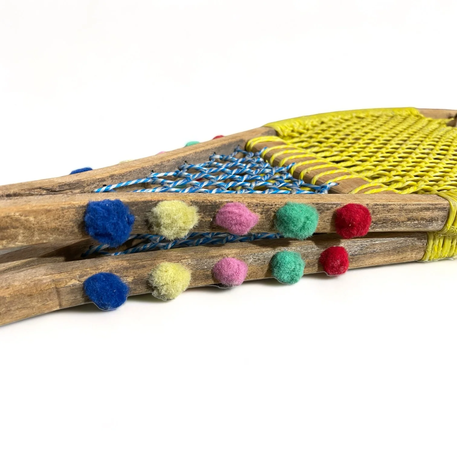Yellow and blue wooden vintage snowshoes with leather straps.