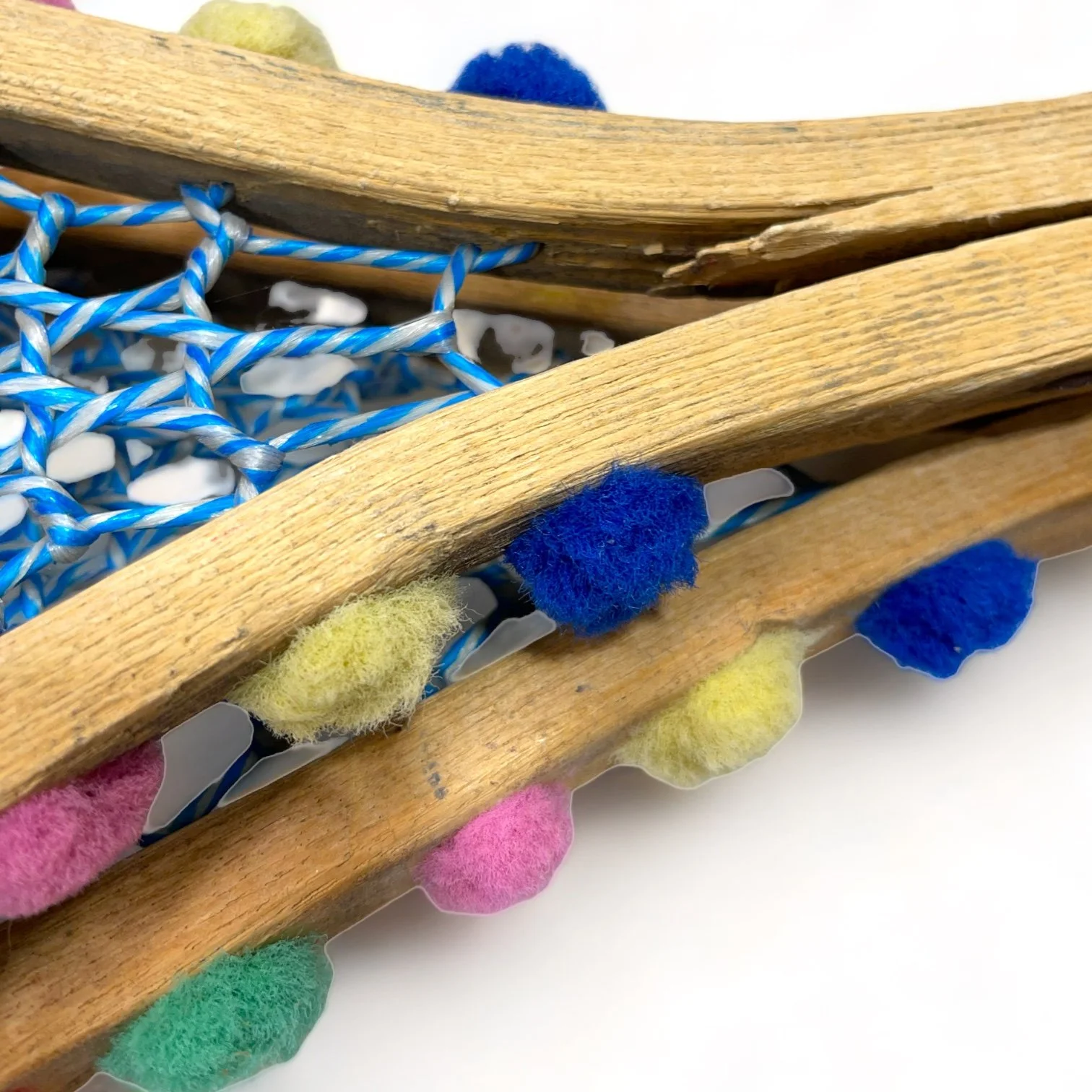 Yellow and blue wooden vintage snowshoes with leather straps.