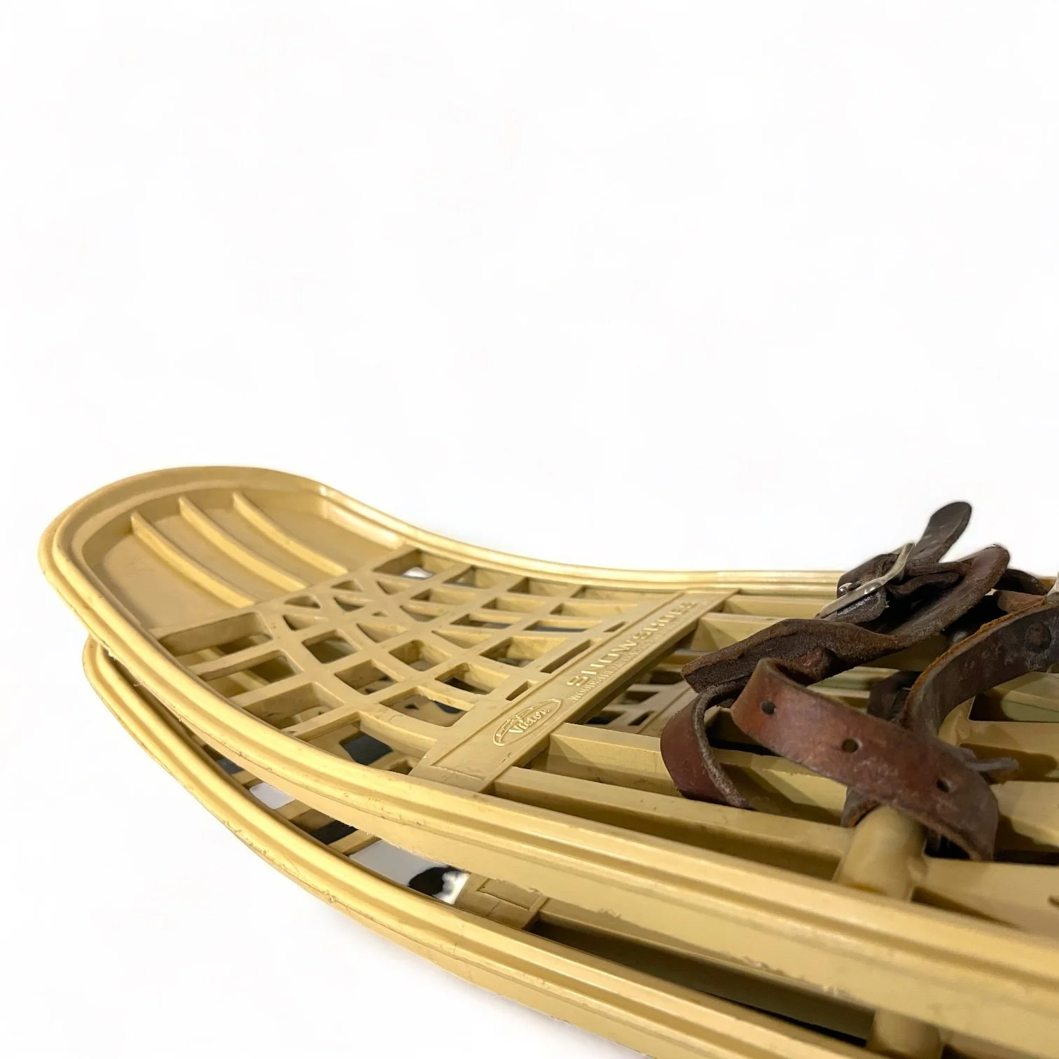 Pair of beige plastic Victor snowshoes with leather bindings.