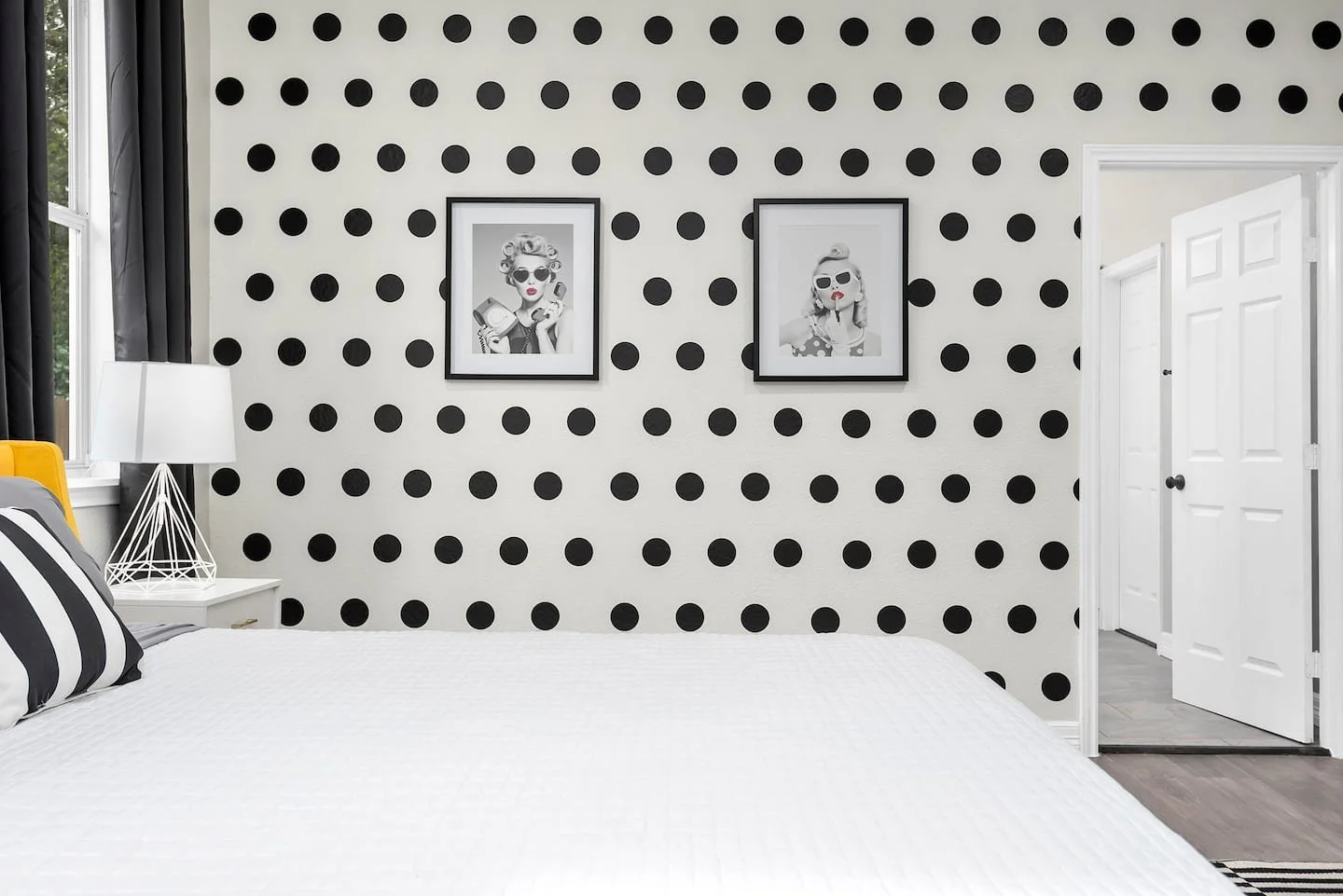 Black polka dot wall decals shown on a white wall of a retro primary bedroom.