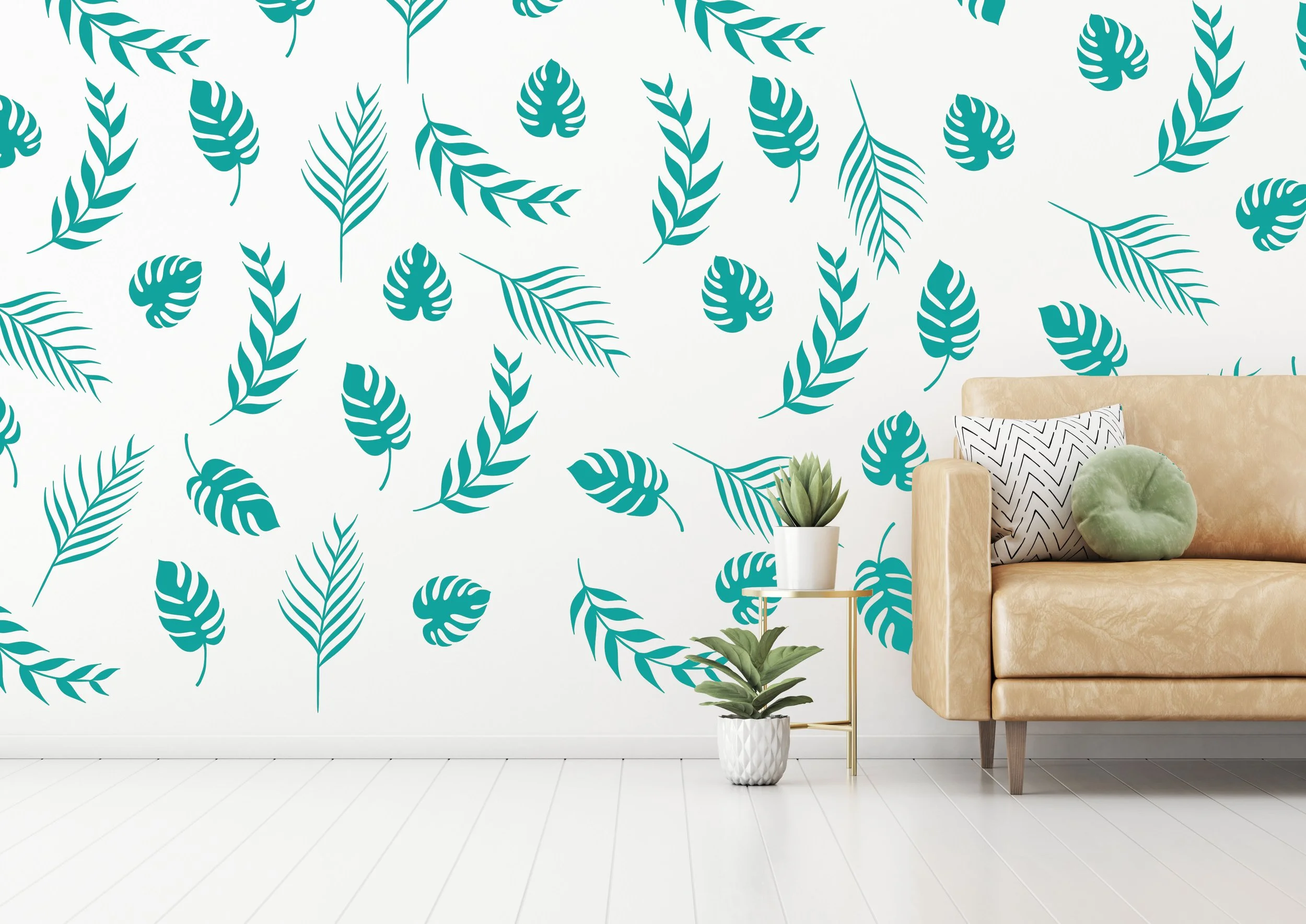 Palm leaf vinyl wall decals in turquoise on a white wall behind a modern leather couch with potted succulents.