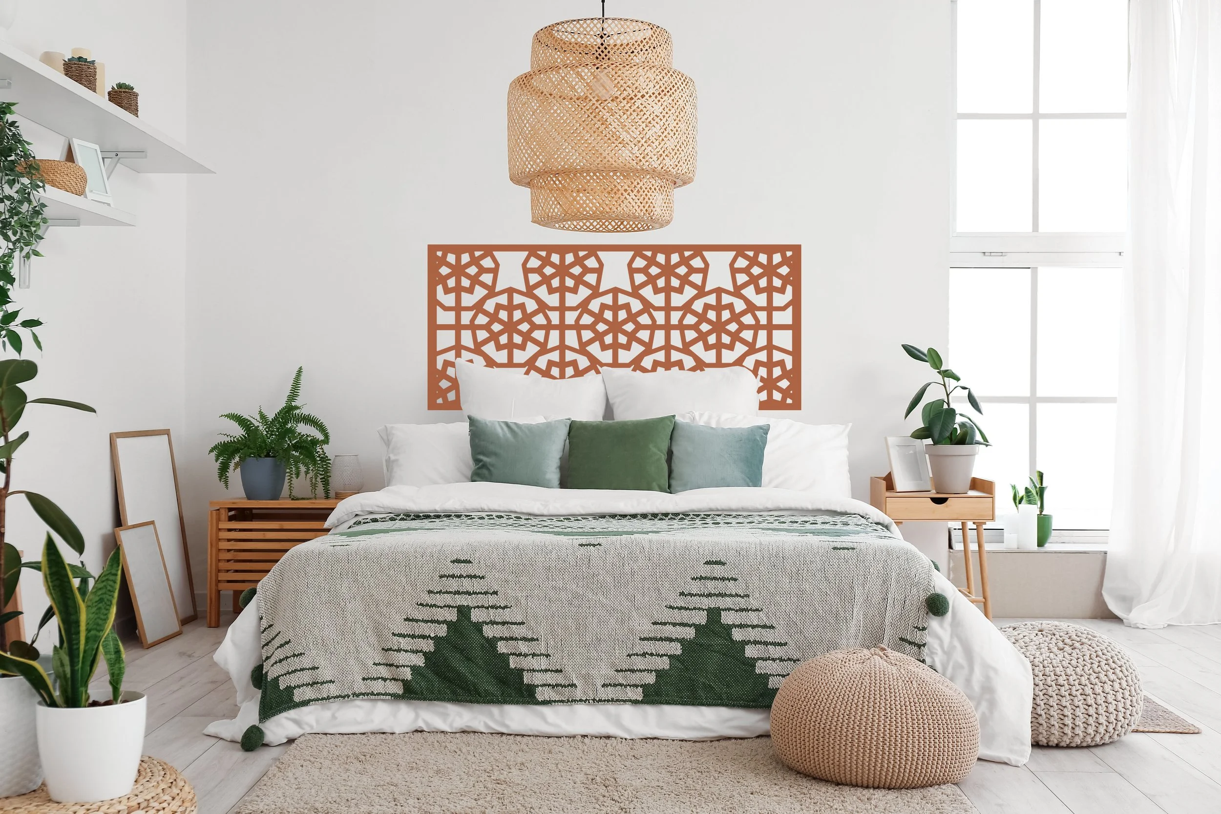 Rectangle shaped wall decal with a geometric snowflake pattern and used as a makeshift headboard above a bed in a boho modern bedroom.