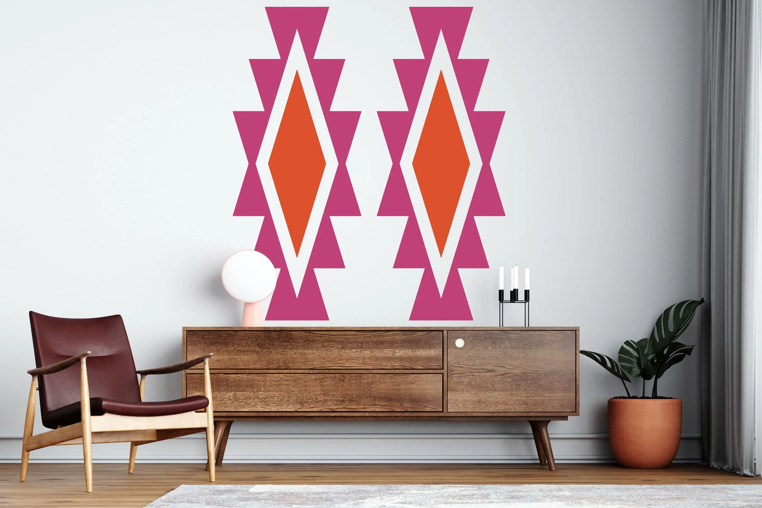Aztec geometric shapes wall decal in pink and orange on a white wall of a modern room.
