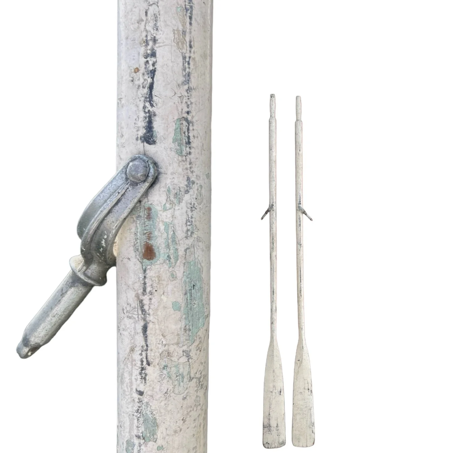 Vintage pair of white chippy painted wooden boat oars leaning against a brick wall, complete with oar locks and added eye bolts to use as wall hangings.