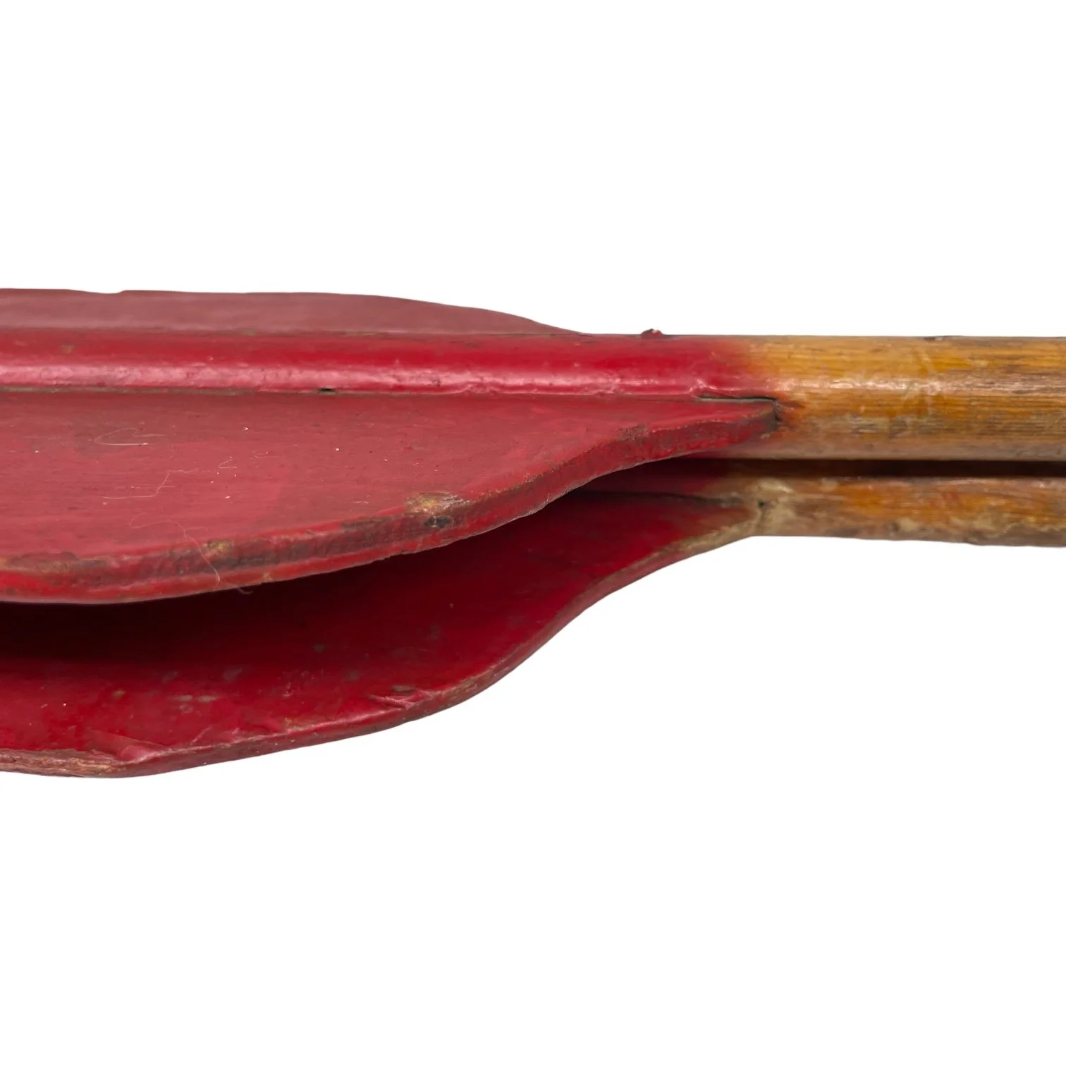 A pair of vintage wooden boat oars with aged red paint on the paddles.